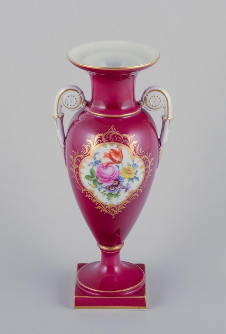 Meissen, Porzellanvase mit zwei Henkeln.
Burgunderfarbene Verzierung. Polychrome Blumenmotive.
Handbemalt. Goldverzierung. Überglasur.
Mitte des 20. Jahrhunderts.
Markiert.
Erste Fabrikqualität.
Perfekter Zustand.
Abmessungen: Höhe 25,0 cm x