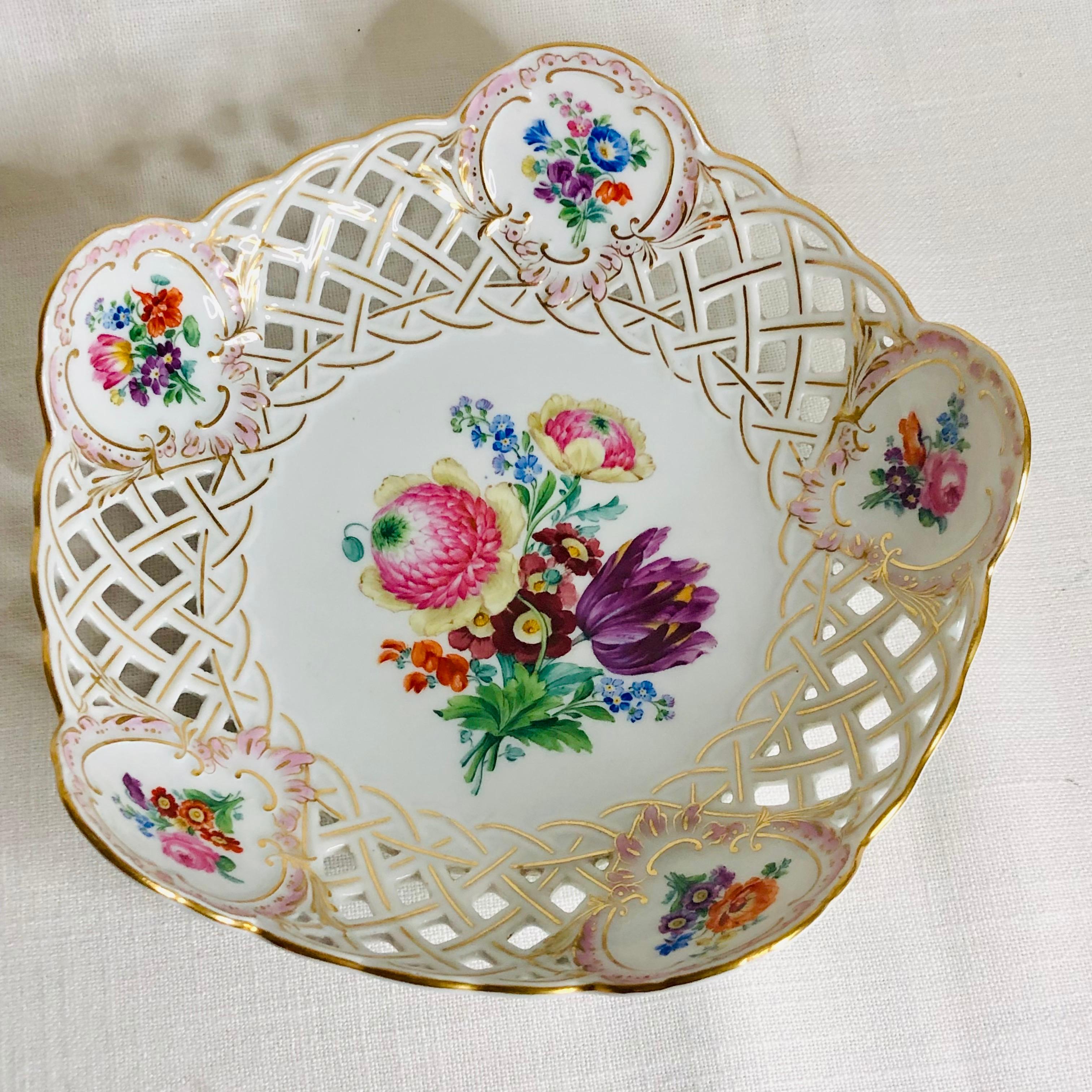 I am offering you this beautiful Meissen reticulated and fluted bowl. It has a bright and colorful large flower bouquet in the center of the bowl with a stunning purple tulip surrounded by other beautiful flowers. Inside the fluted gilded border,