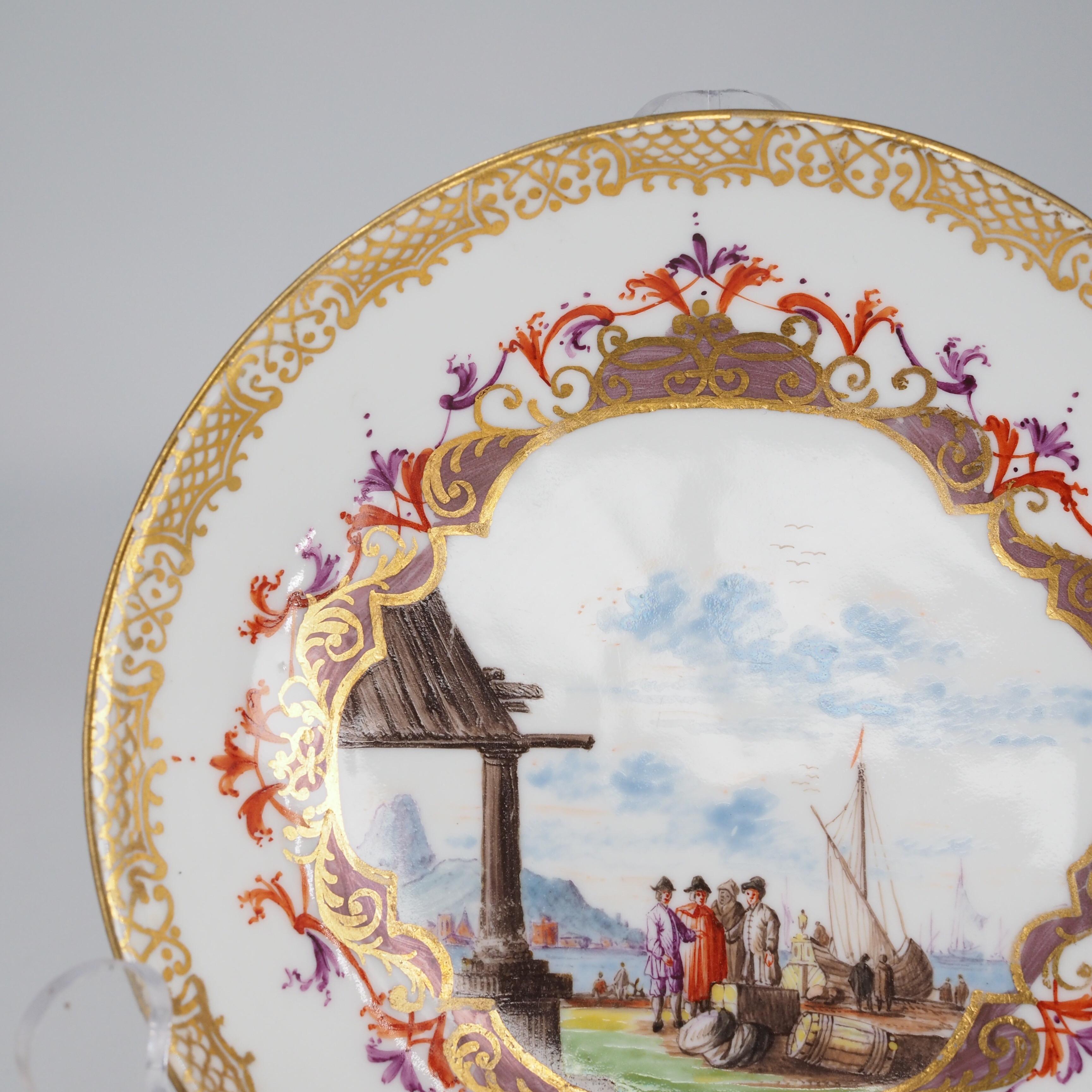 Meissen saucer well painted with a harbour scene of merchants by a quay, ships & cities in the distance, within an elaborate cartouche of iron red, purple & Böttger lustre, the rim with fine gilt scrolling border, the reverse with three