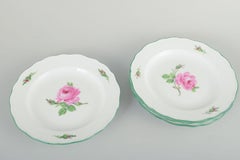 Meissen. Set of four porcelain plates with pink roses and green rim. 1930s