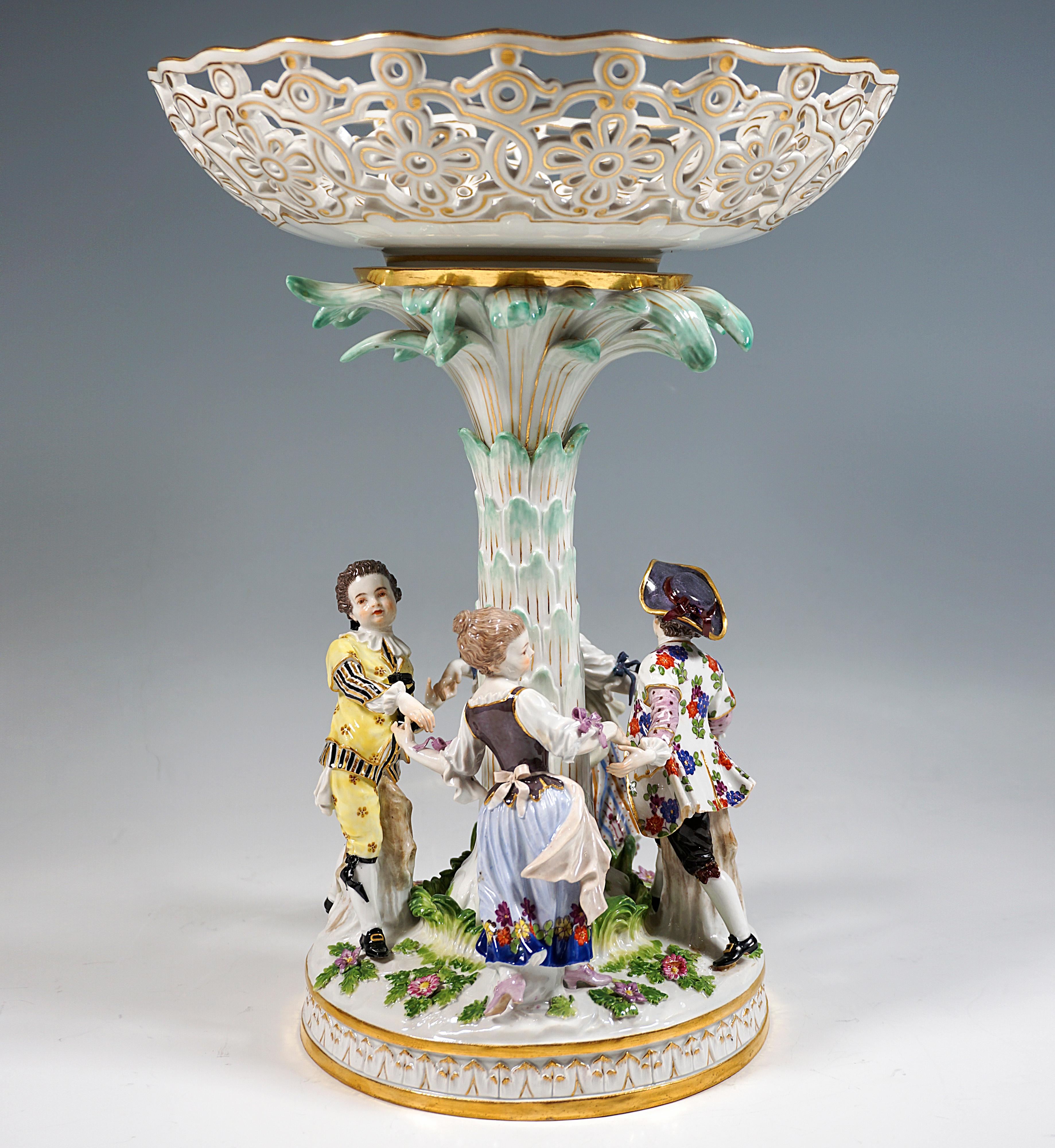 Four gardener children, two girls and two boys, dancing hand in hand in a circle around a palm-like plant, on the crown of which rests a breakthrough bowl, the figures are wearing elaborate rococo rural style clothing, which is equipped with the