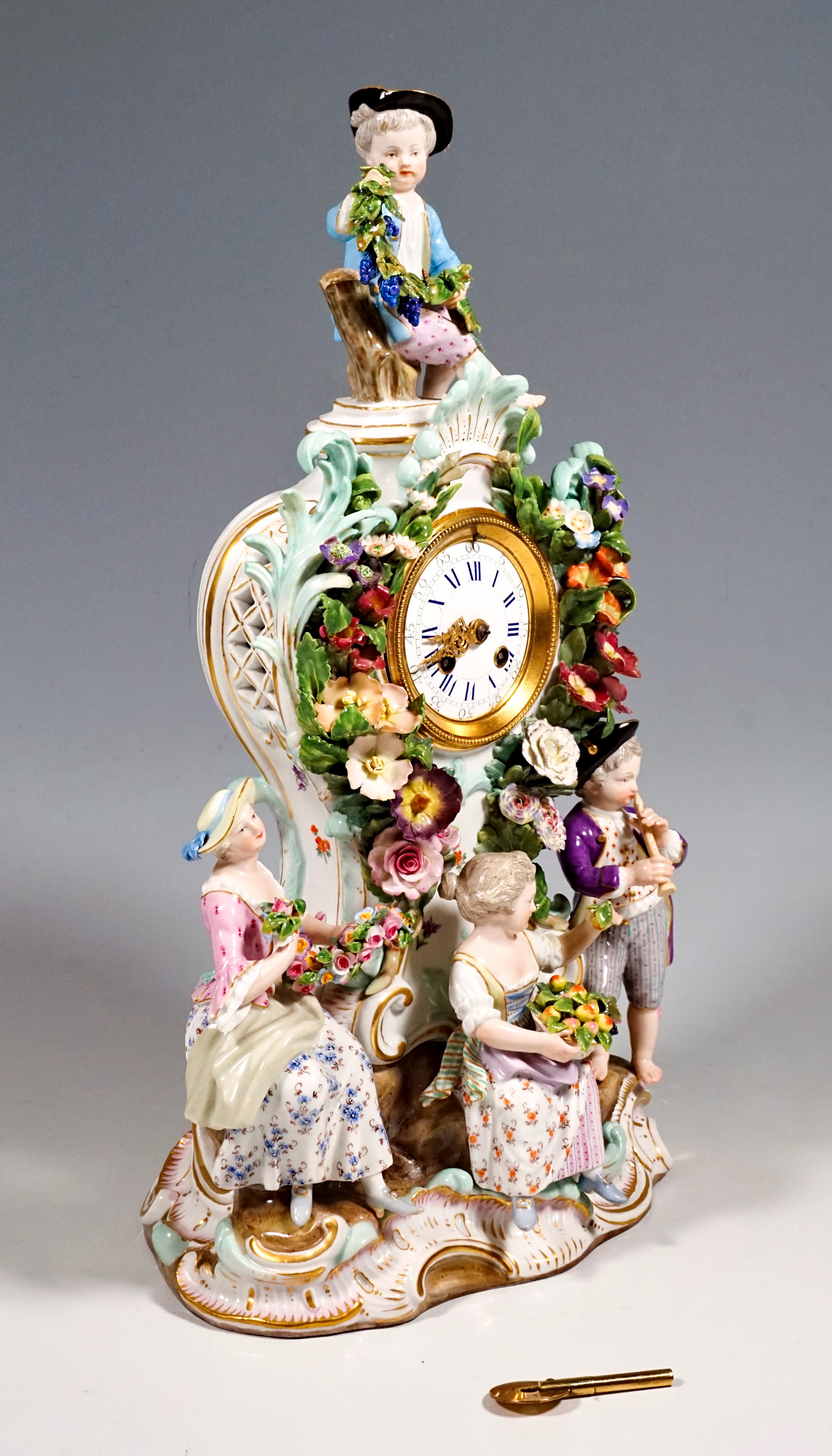 The clock was designed by Leuteritz in Rococo style using old shapes: the clock case rises on a rock base with gold rocailles, richly decorated with delicate, three-dimensional flowers, leaves and rocailles that play around the dial. Below three