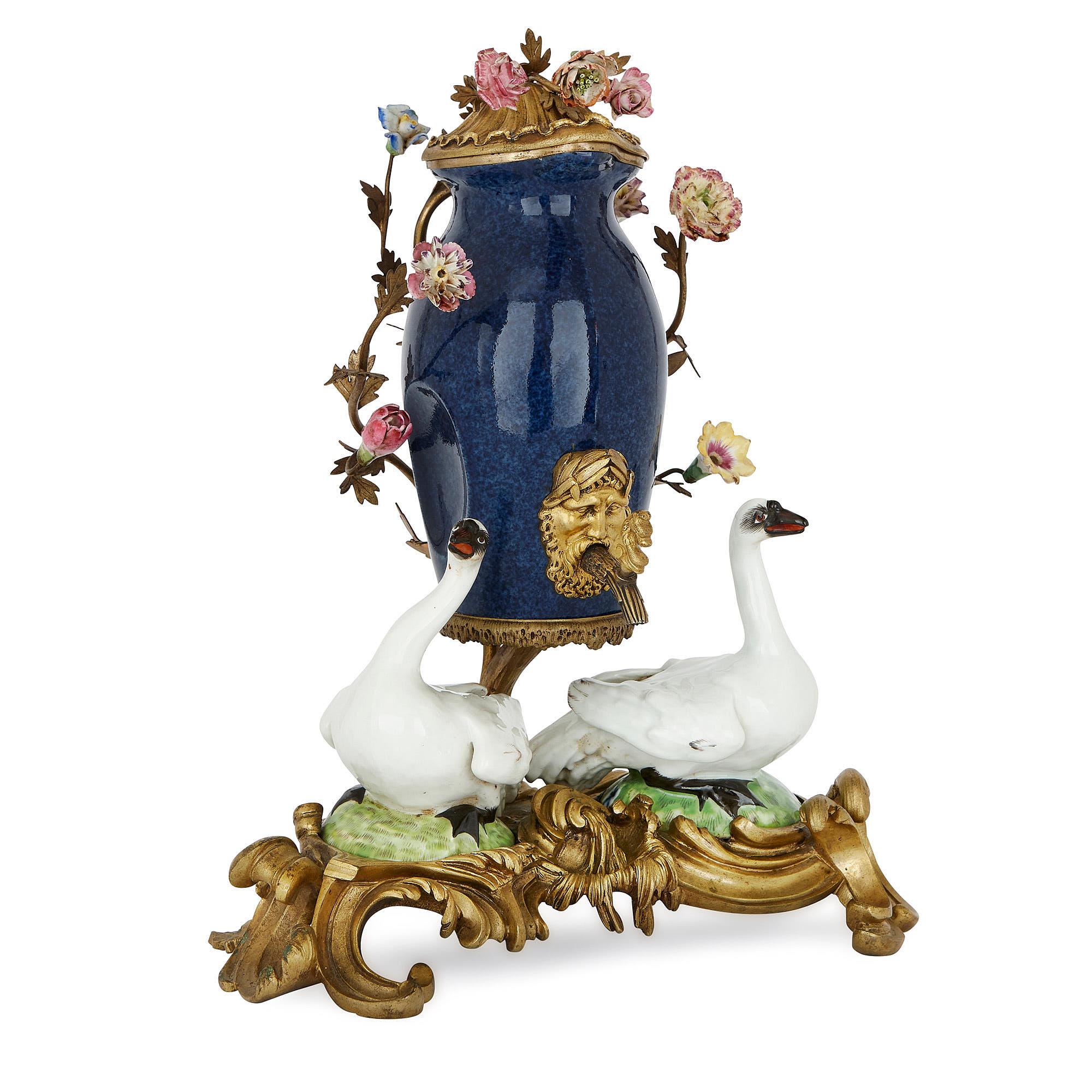 Esta vistosa fuente de porcelana para mesa, de estilo alemán Meissen, fue fabricada en el siglo XIX por la empresa francesa Samson et Cie. 

La fuente de mesa consta de un jarrón central de porcelana que se eleva en el aire mediante un soporte de