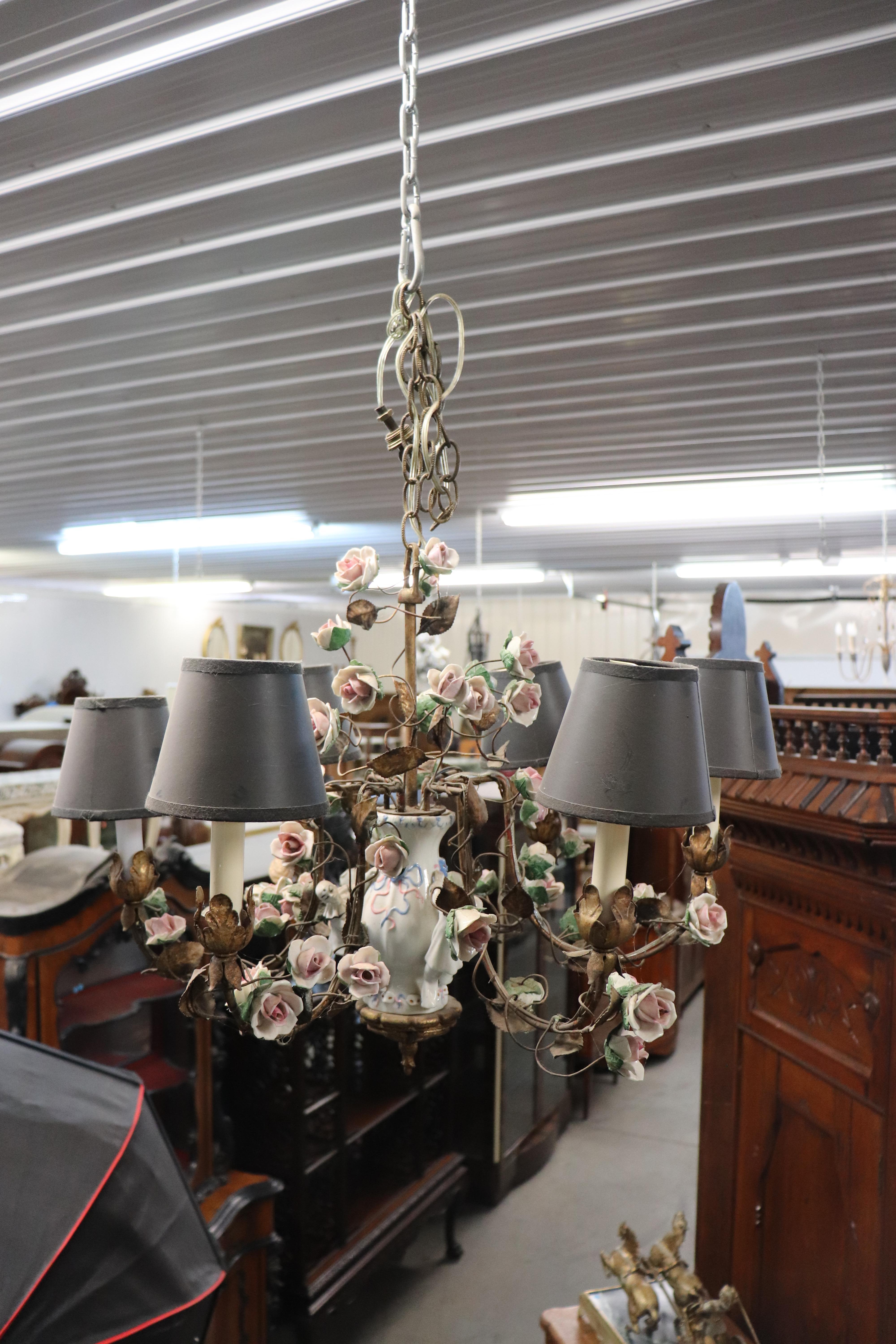 This is an extraordinary porcelain figural chandelier with what appears to be clowns climbing the base of the chandelier and masks from a theater production of some kind. The chandelier flowers are Meissen quality porcelain and decadently realistic.
