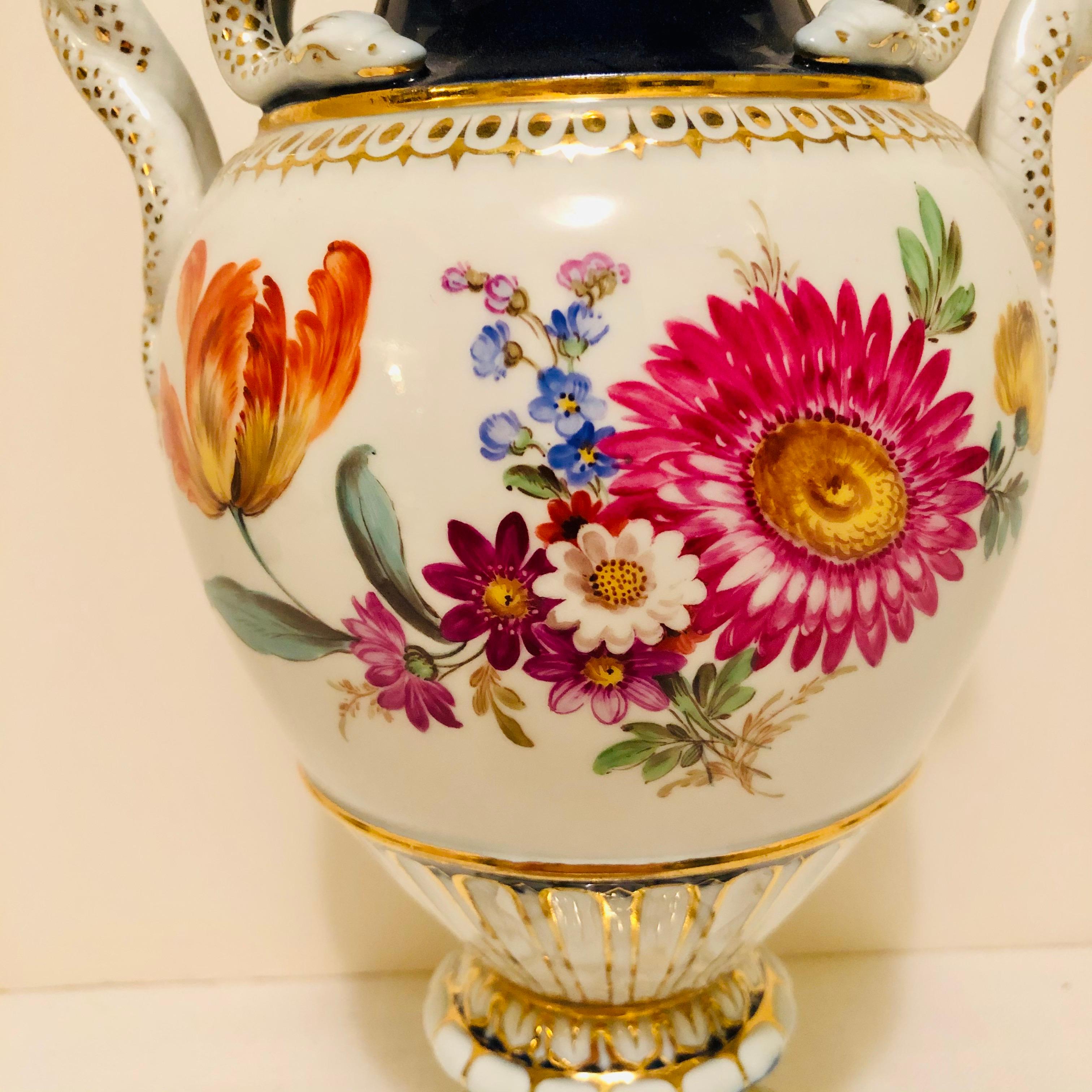 I want to offer you this wonderful cobalt Meissen vase with different lovely hand painted flower bouquets on either side with snake shaped handles. This Meissen vase is one of the Meissen company's Classic designs. The flower bouquets are