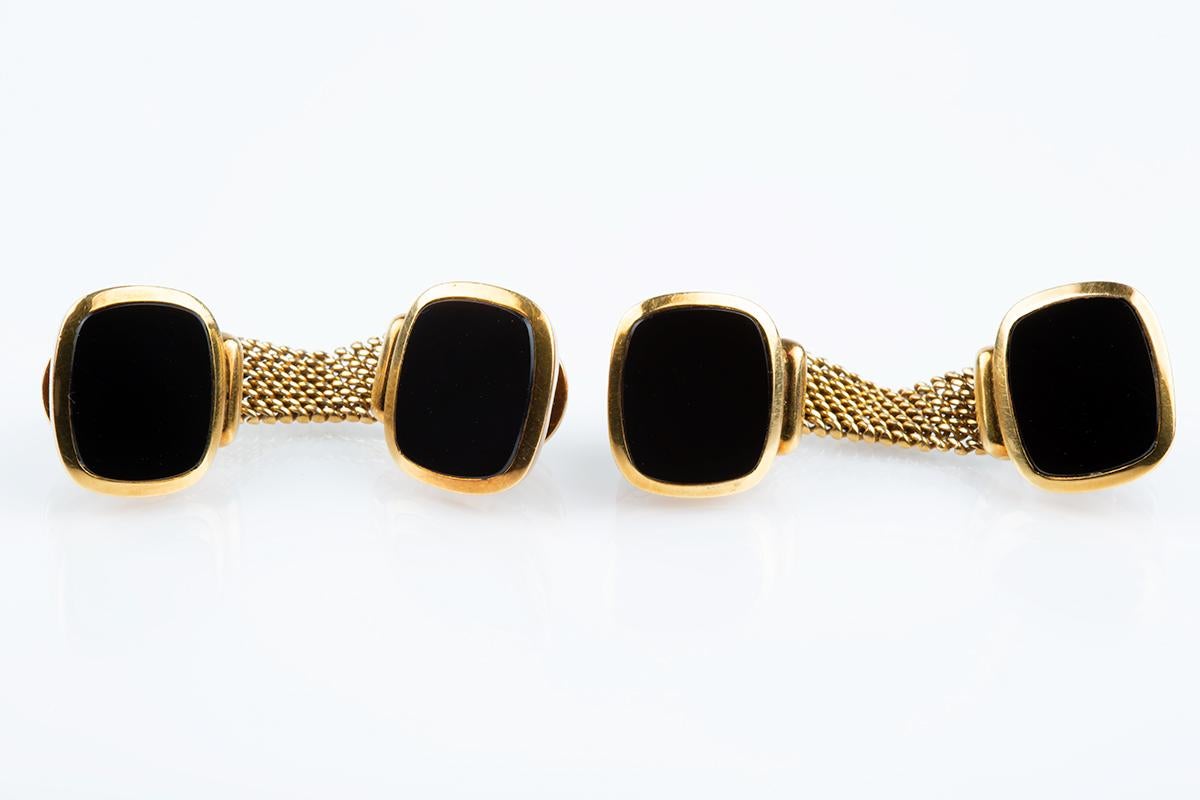 A finely made pair of ‘around the cuff’ cufflinks with chain mesh connections. Each terminal is set with an onyx stone in 18 karat yellow gold clipping together with a snap lock device. Signed by the maker, Meister together with the stamp Em750.