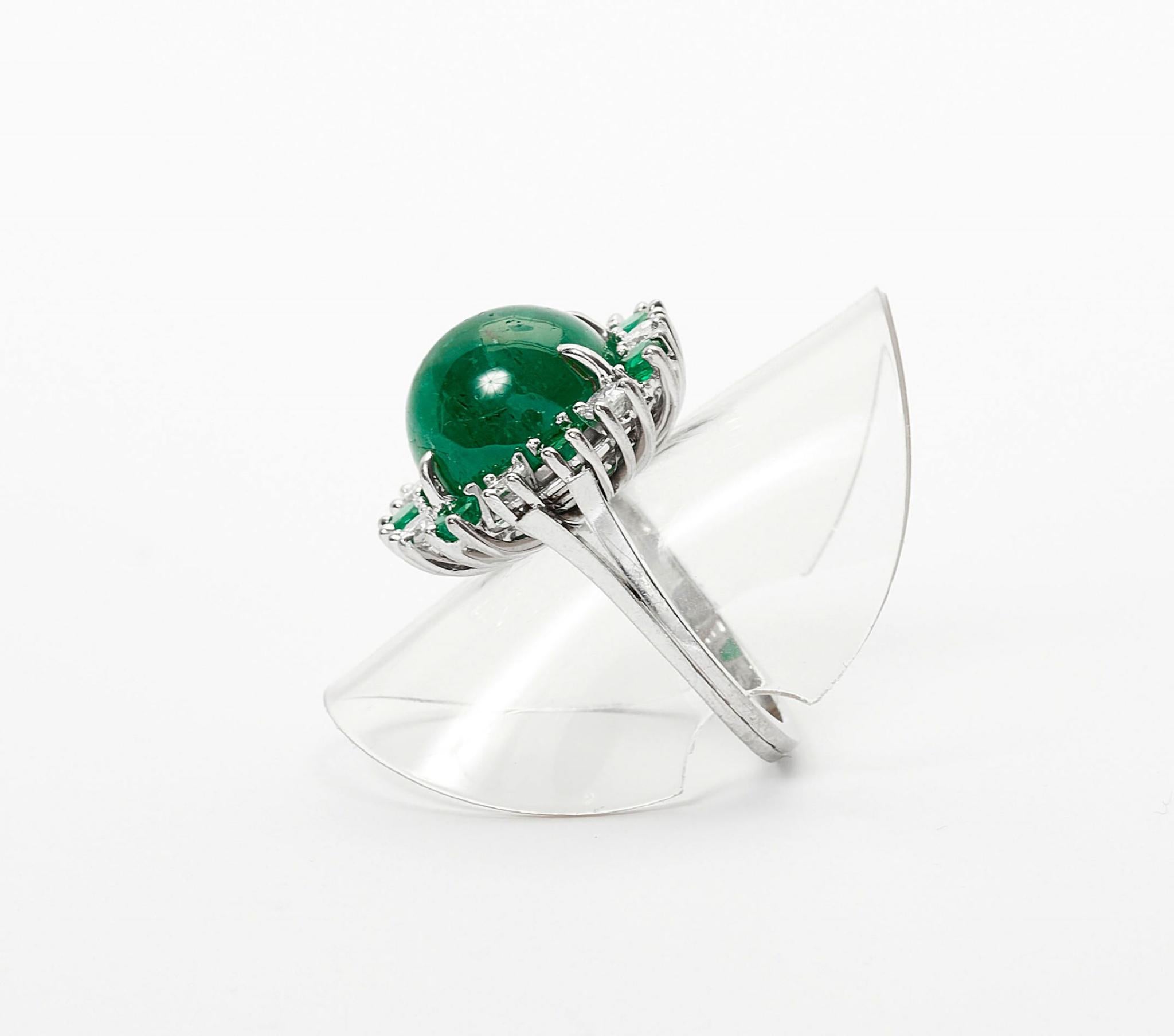 - Set with 1 oval emerald cabochon of ca. 9.25 ct, surrounded by emeralds of ca. 0.76 ct resp. brilliant-cut diamonds of ca. 0.66 ct. Size ca. 54.
- - White gold 750, 12.2g.
- Accompanied by GIA report no. 1493211175, stating that the emerald are