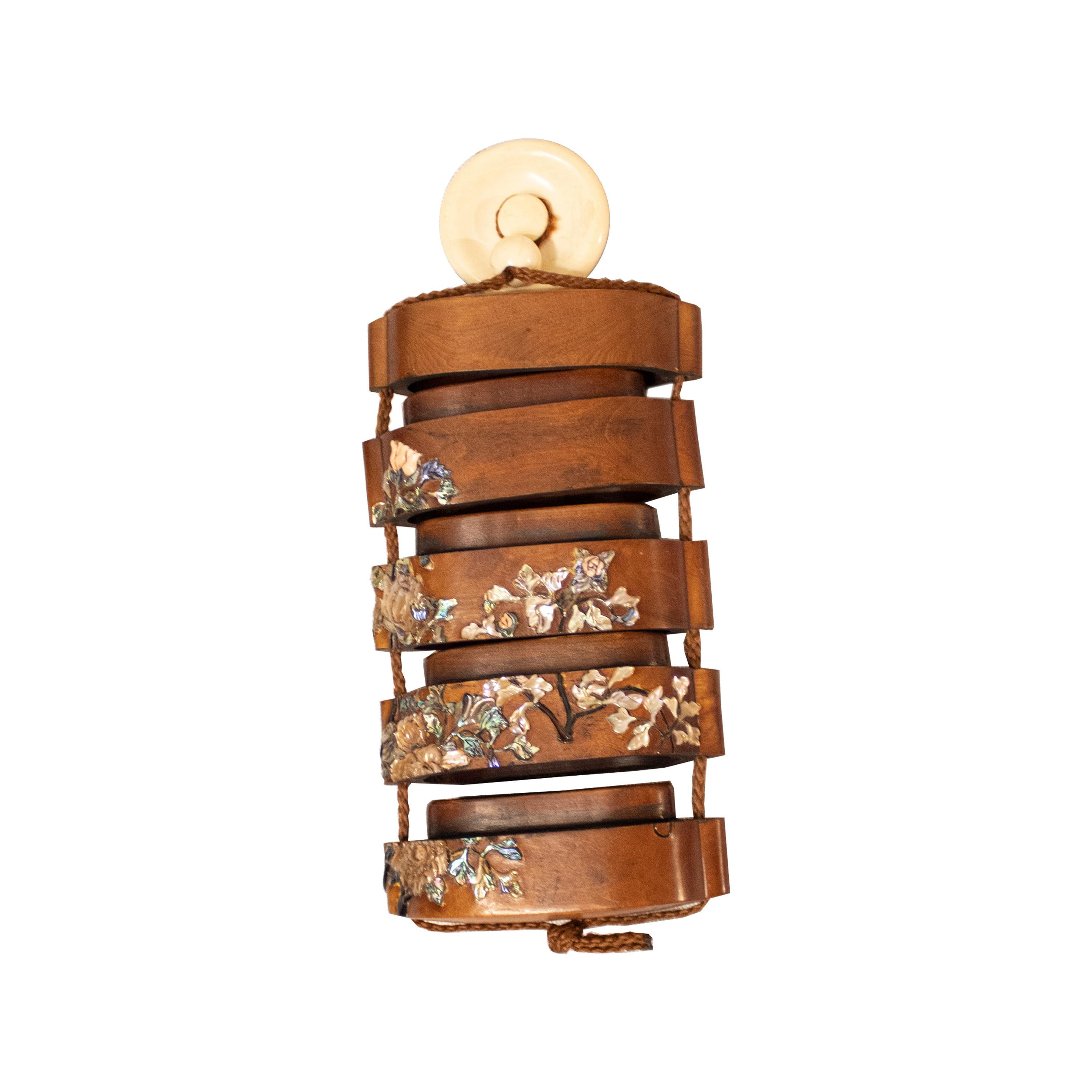 Inro is an ancient traditional Japanese box used to carry and store small items such as tobacco, money, paintbrushes, and other objects. The inro is a stack of small boxes hanging from a 