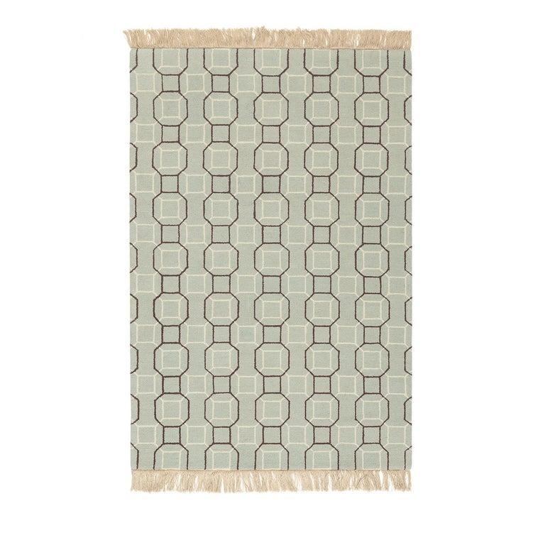 Sophisticated and timeless, this rug has a refined allure and features a delicate green background over which geometric lines in brown and white cross to create a decorative pattern inspired by Moroccan ceramic mosaics. Designed by the Karpeta Team,