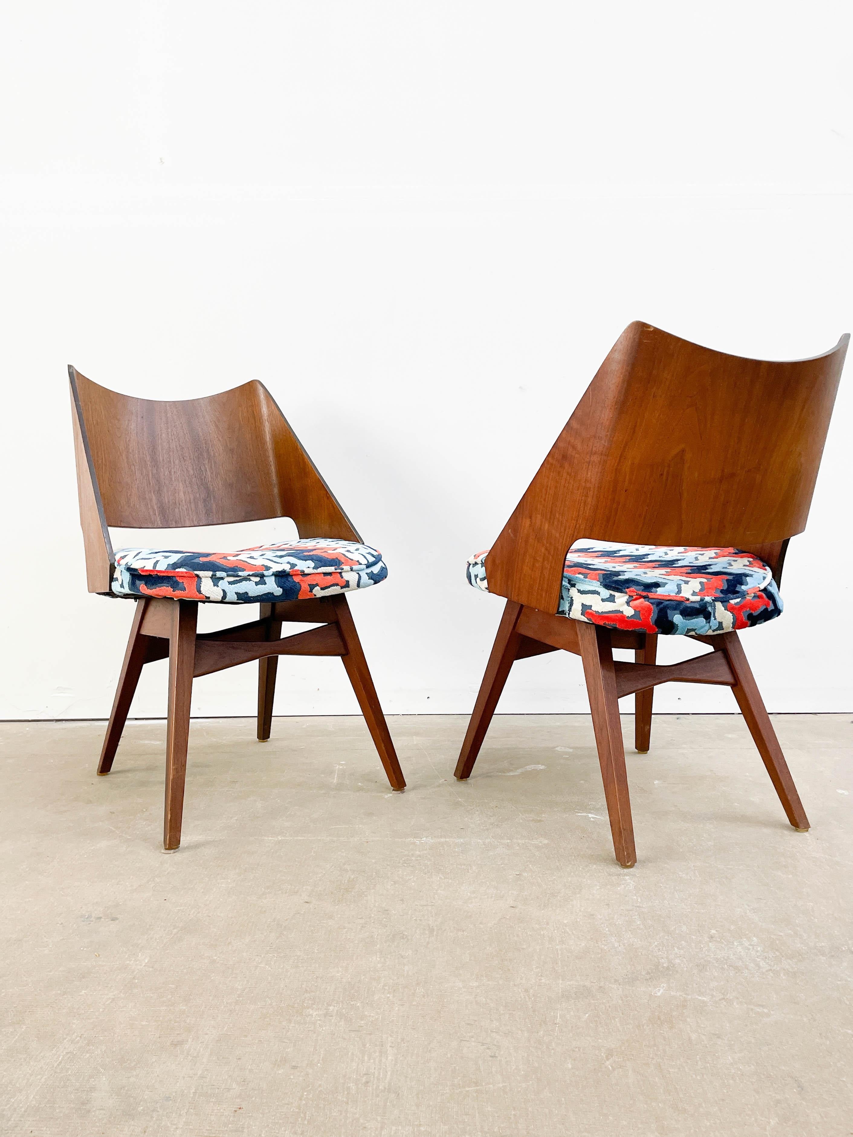 Superb Mid-Century Modern dining chairs with bent plywood backs and walnut bases. Featuring beautiful walnut veneer on the backs and Mel Abitz' signature bowtie stretchers between the legs, these chars look great from every angle. These chairs were