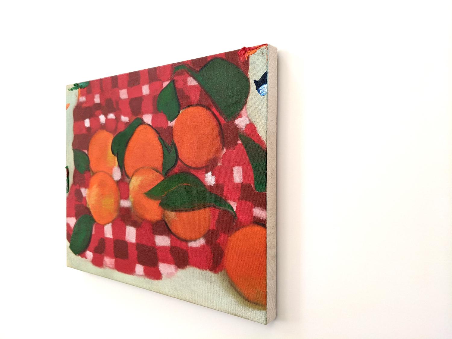 Montreal born artist Mel Davis created this beautifully curated composition of bold colours—a few oranges with green leaves scattered against a background of red and white gingham cloth. Davis was influenced by the colourful and fluid work of French