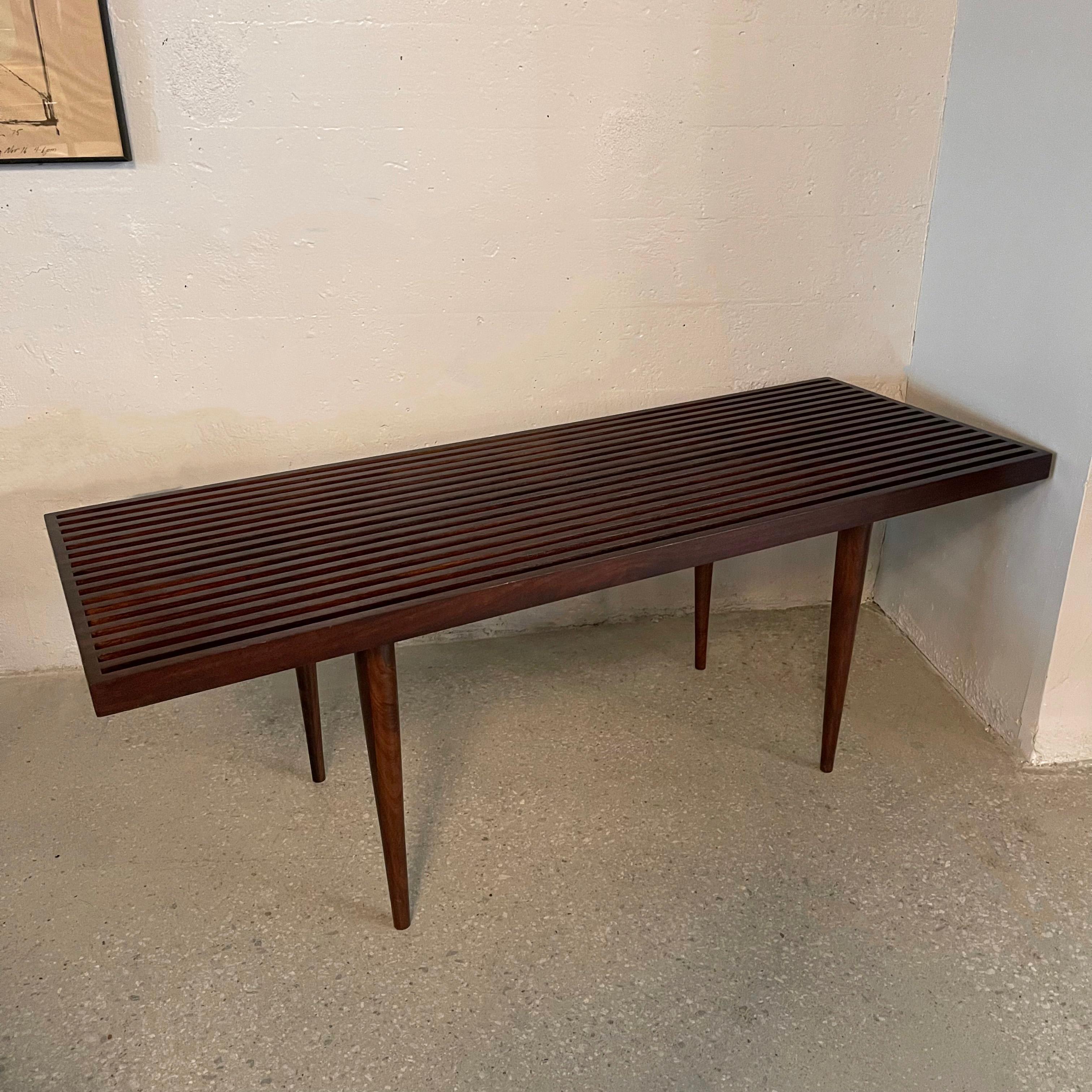 Mid-Century Modern, slat walnut coffee table bench with elegant dovetail details and tapered legs designed by Mel Smilow for Smilow-Thielle.