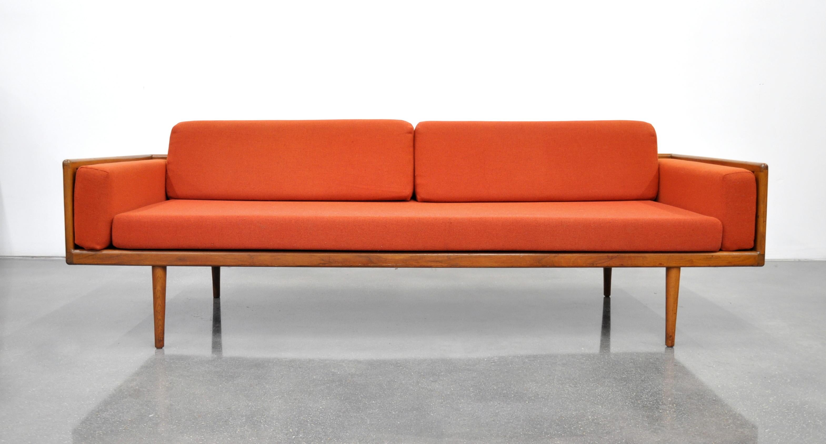 Stunning and rare vintage Mid-Century Modern box sofa and club chair living room set, designed by Mel Smilow and dating from the 1950s. The couch and armchair feature exposed solid walnut cases raised on slender tapered legs, imparting a Minimalist