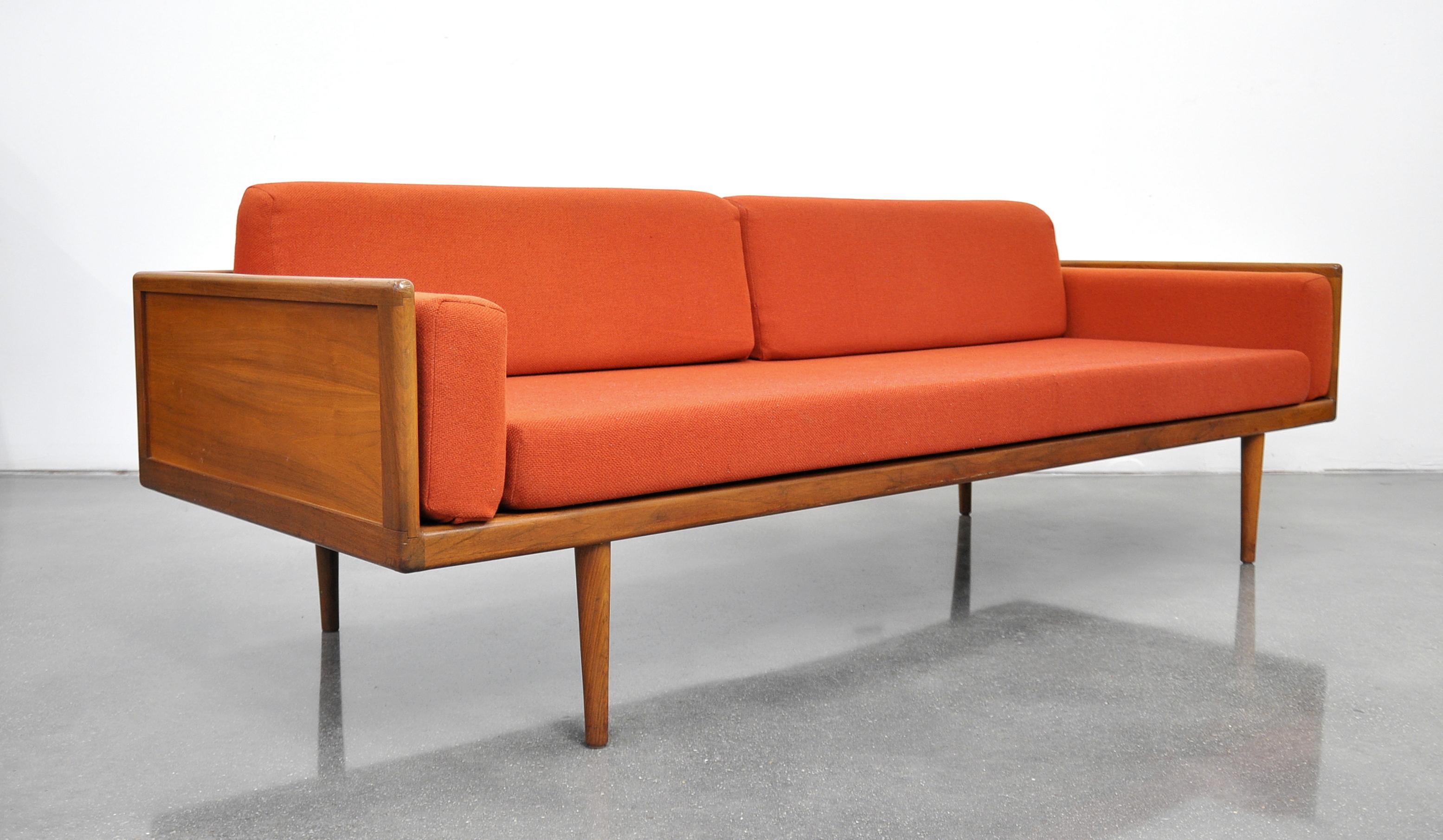 A stunning and rare vintage Mid-Century Modern box sofa, designed by Mel Smilow and dating from the 1950s. The couch features an exposed solid walnut case raised on slender tapered legs, imparting a Minimalist aesthetic to the floating design.