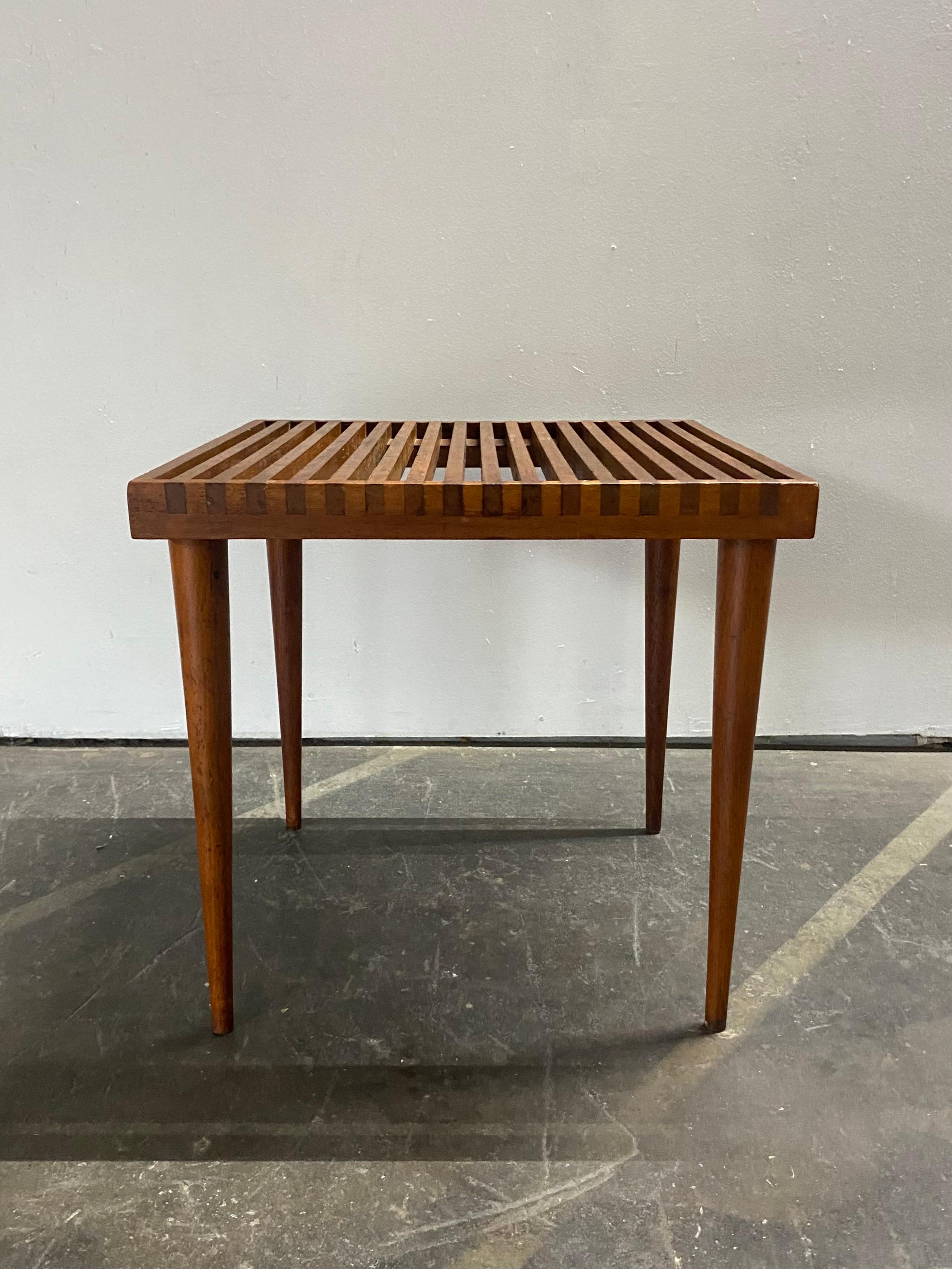 Beautiful Mel Smilow slat table in walnut. Elegant design with exposed joinery and tapered legs creates a beautiful shape in both form and function. Can be used as an end table or bed side table.