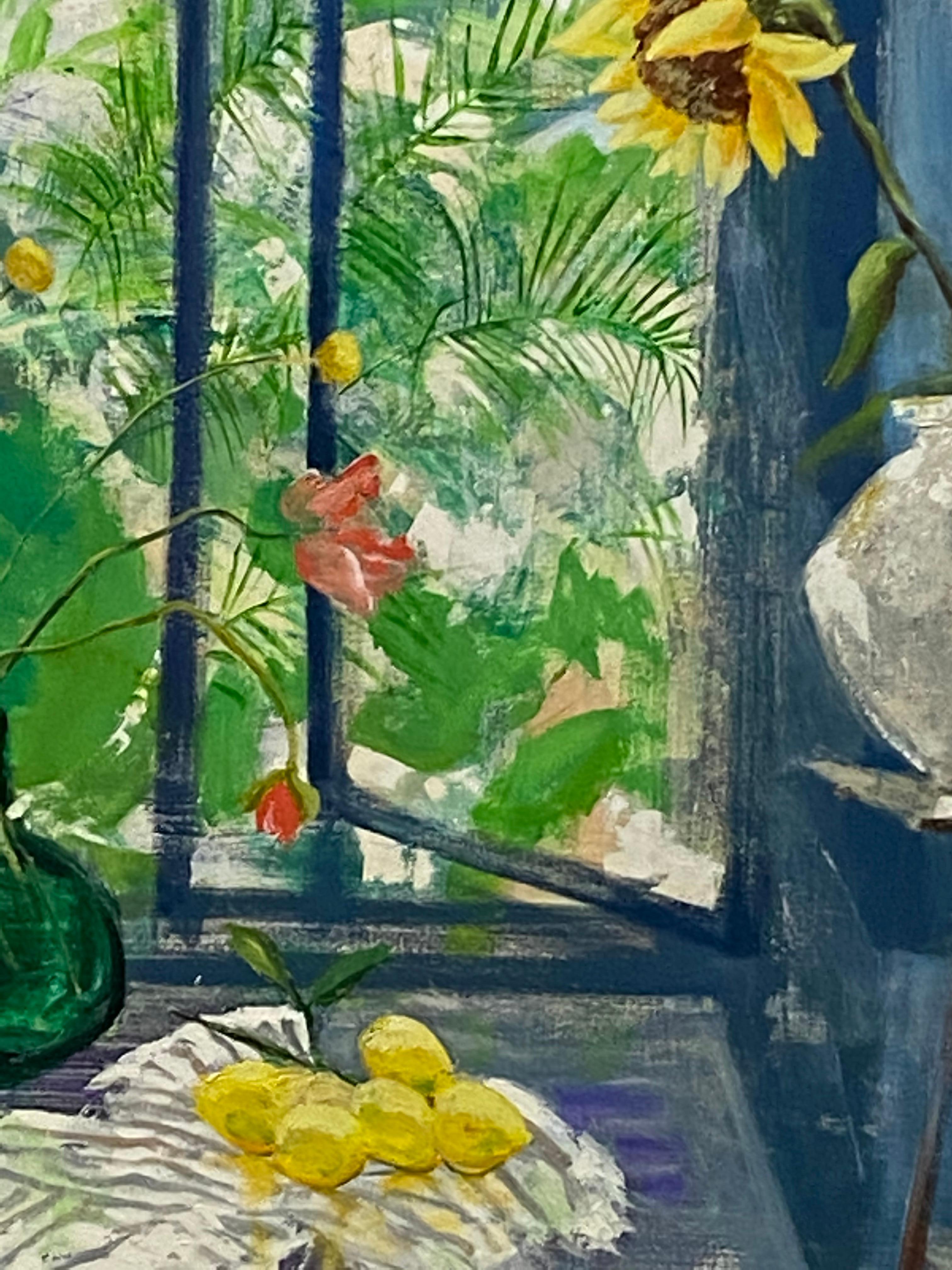 En este cuadro contemporáneo al óleo sobre lienzo, un interior luminoso y acogedor presenta un bodegón de alegres girasoles amarillos junto a una mesa con tres limones amarillos y un ramo de flores coral y amarillas en un jarrón sobre un mantel a