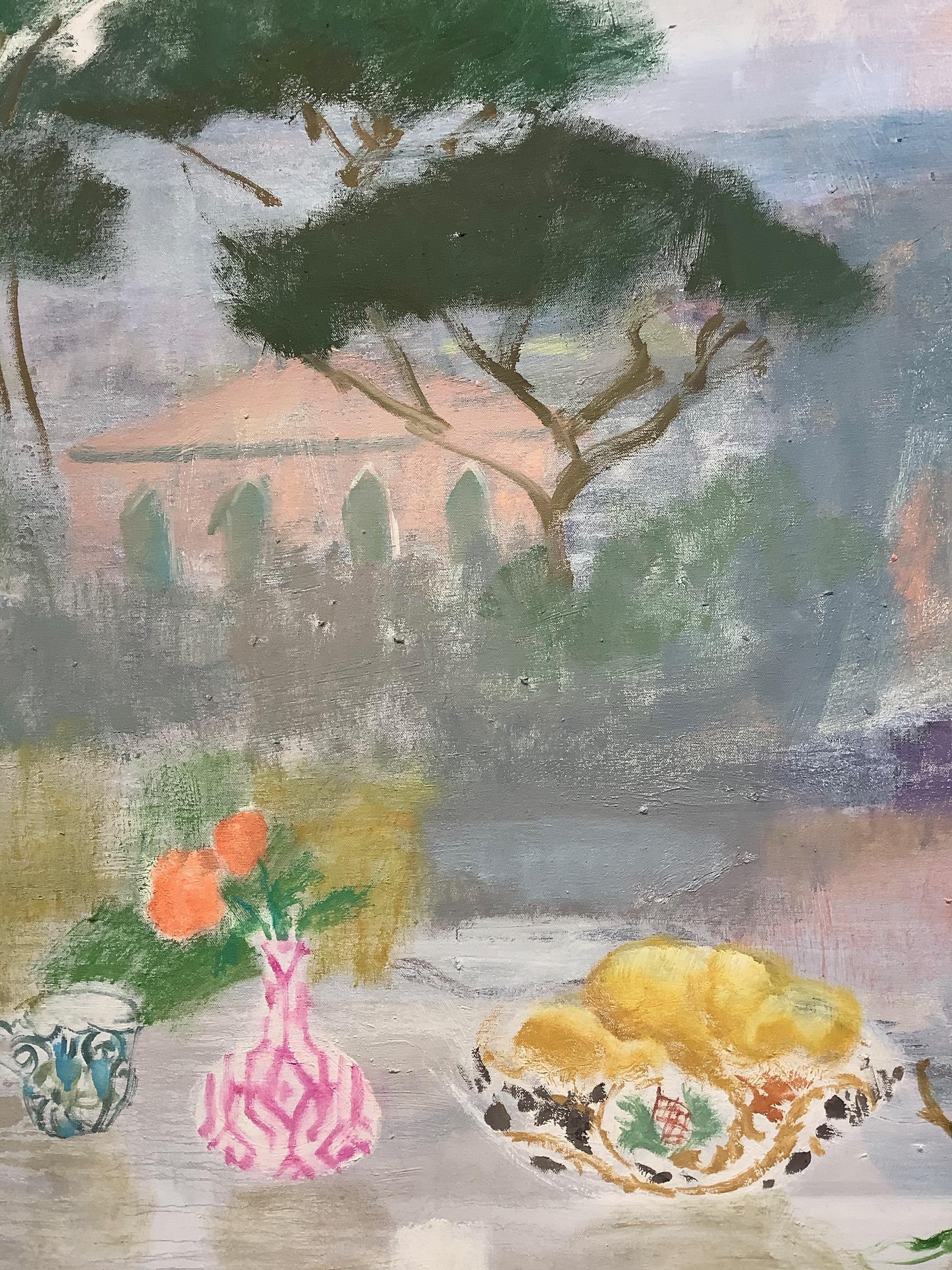 Eine luftig-leichte, einladende Szene im Freien mit einem Stillleben-Arrangement aus Pfirsichblüten in einer rosa-weiß gemusterten Vase neben einer bemalten Obstschale und einer blau gemusterten Teetasse, die auf den friedlichen Moment eines