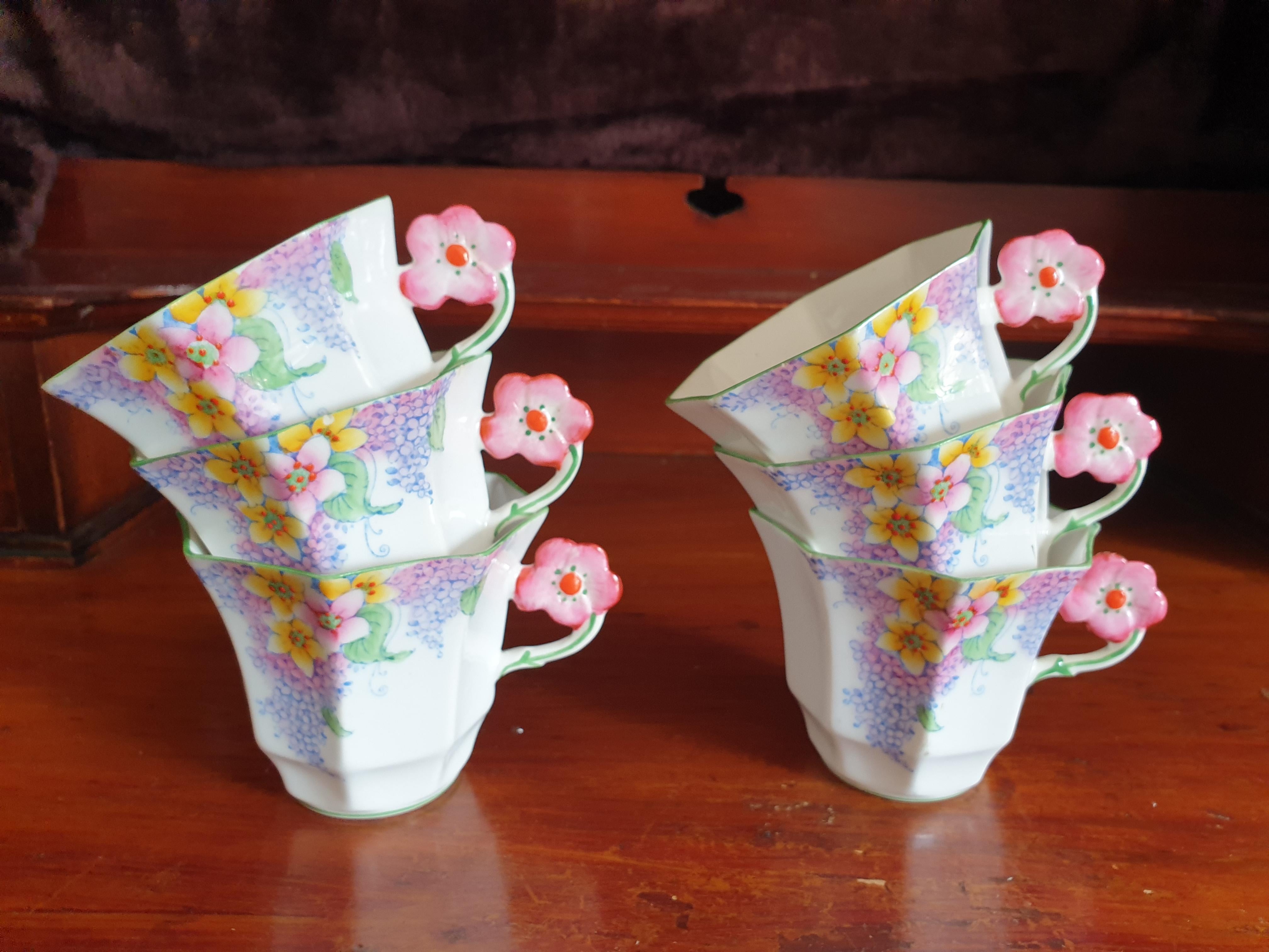 Melba pink flower handle tea service patten number 3787, Lilac time from the Art Deco period. This set comprises 6 hexagonal shaped cups and saucers, 6 cakeplates, sugar bowl and creamer and 1 large cakeplate. All in perfect condition. Each piece is