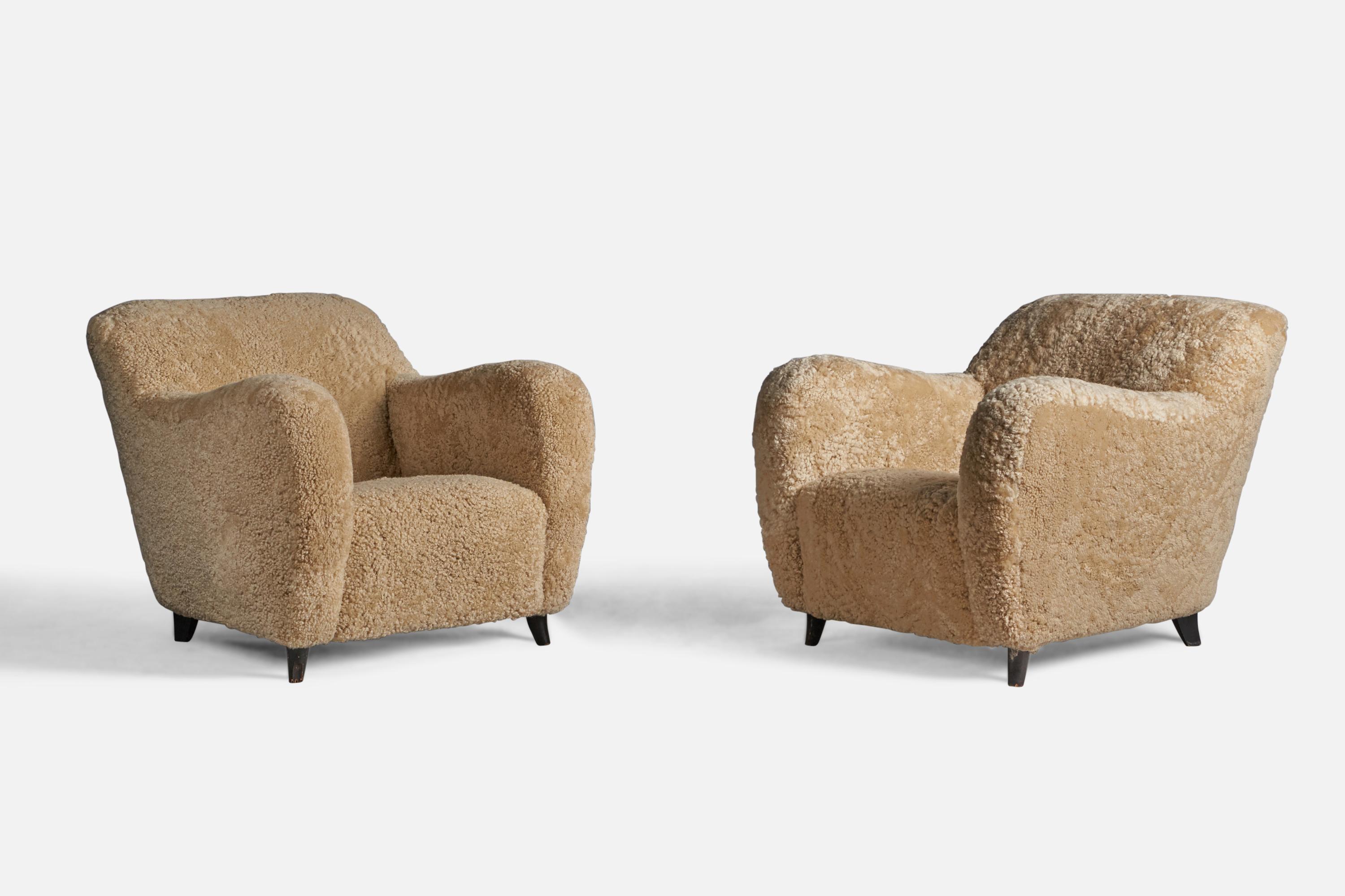 A pair of sizeable beige shearling and dark-stained wood lounge chairs attributed to Melchiore Bega, Italy, 1940s.

15.5
