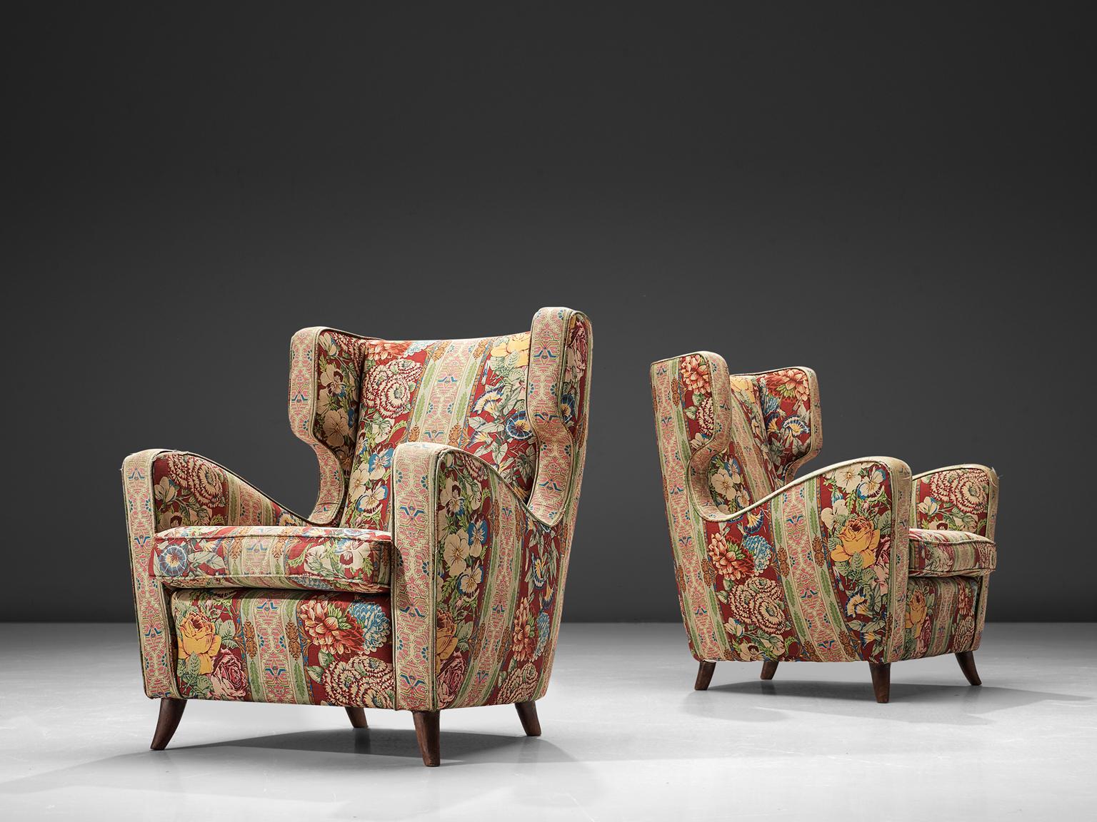 Melchiorre Bega ‘attributed’ two lounge chairs, fabric, wood and brass, Italy, 1940s.

This wonderful pair of elegant and small wingback chairs are upholstered with a colorful, bold floral fabric. The edges and corners of these chairs are very