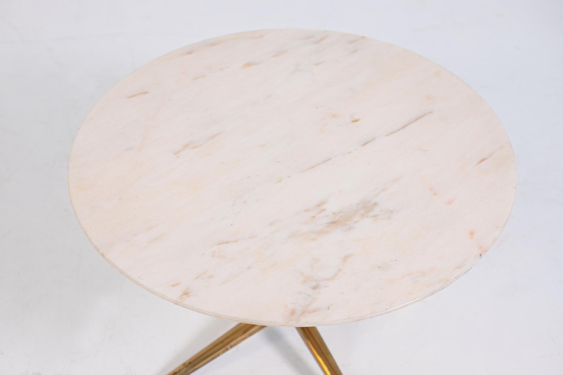 Elegant and refined Melchiorre Bega coffee table from the 1950s. The coffee table has a marble top with pink veins, The Melchiorre Bega coffee table has a single pedestal with four brass legs.The central trunk is made of wood. The Melchiorre Bega