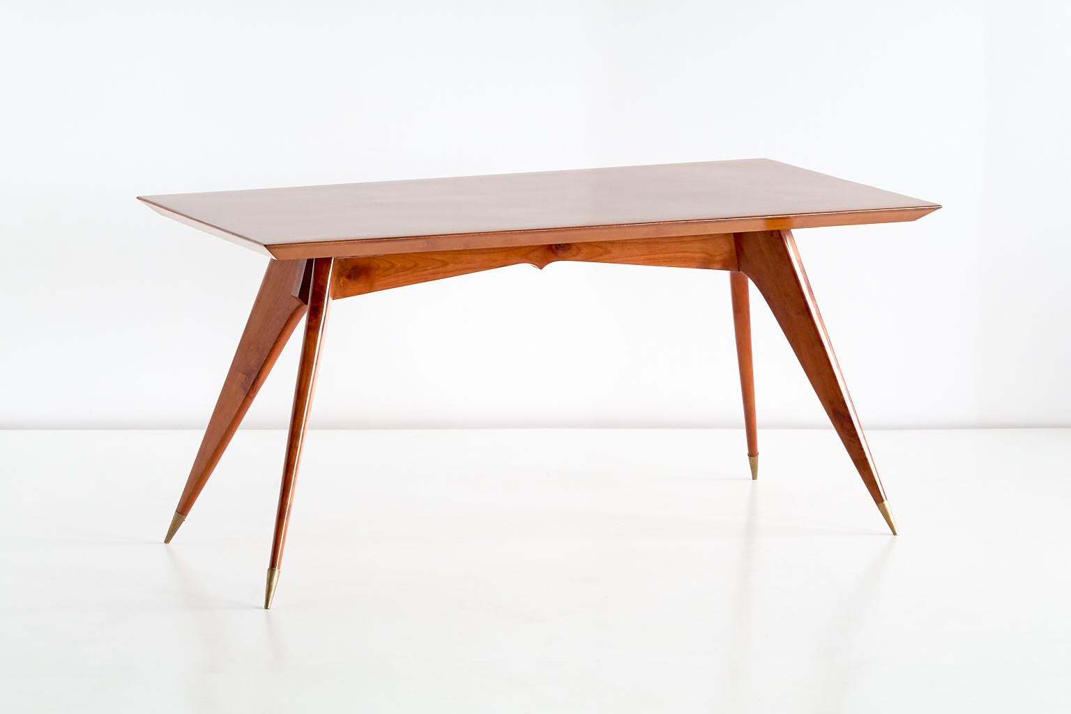 This rare dining table was designed by Melchiorre Bega in the early 1950s. The elegantly pointed legs with brass feet give the table a sculptural and modern silhouette. The grain of the walnut wood completes the attractive design. The table