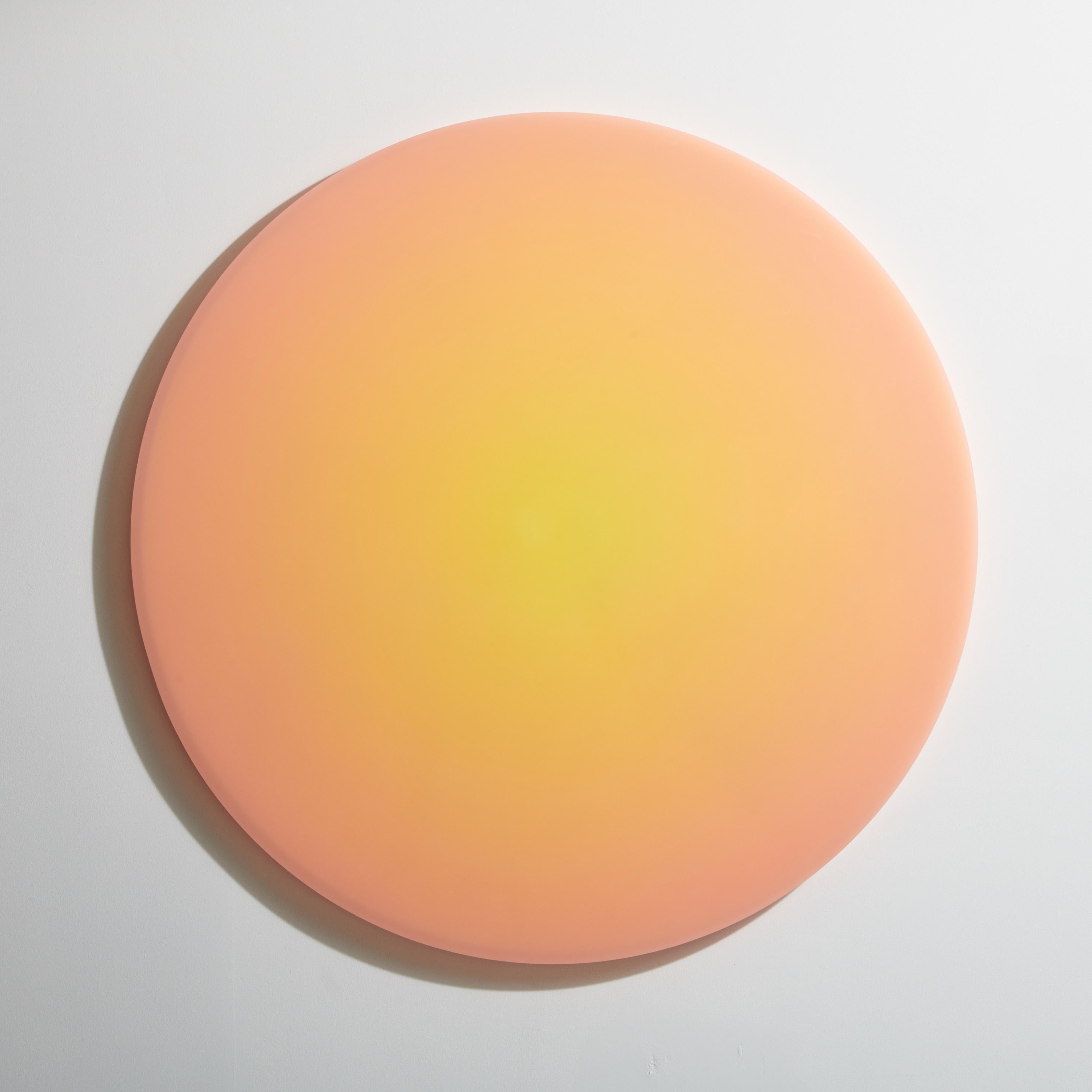 Large circular wall object features a warm hue transitioning from peach to beige. The shifting saturation levels create subtle changes in the way light is refracted from within. The exterior facets are sanded to a smooth-as-glass finish.