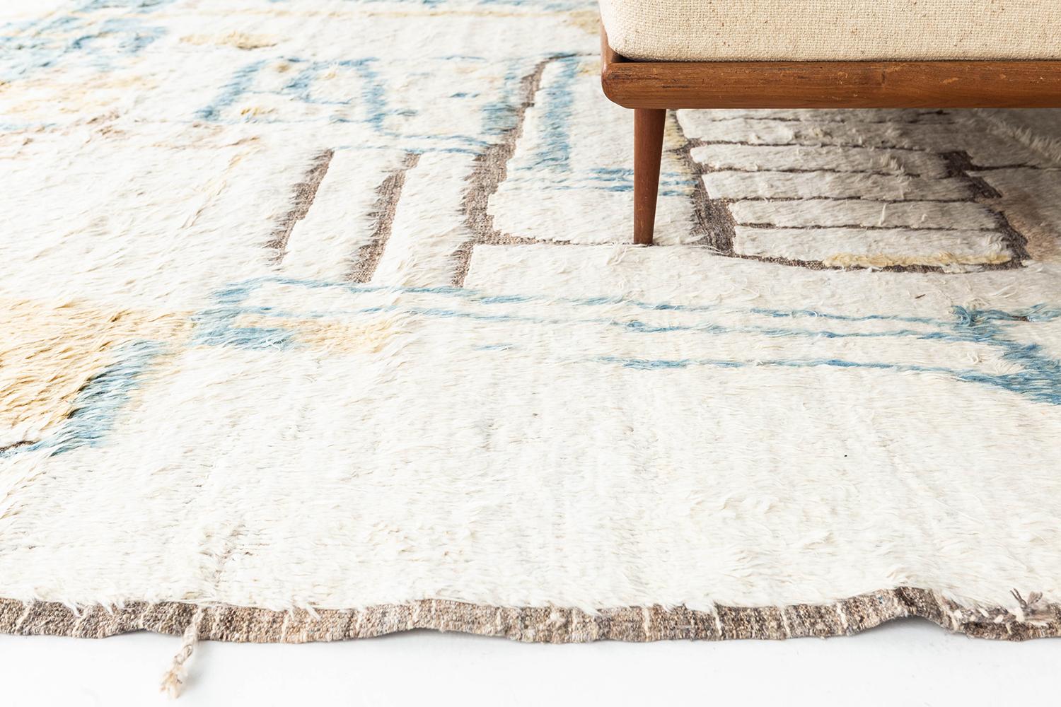 Meliska' is a beautifully textured rug with irregular motifs inspired from the Atlas Mountains of Morocco. Natural blush, golden yellow, and blue surrounded by ivory shag work cohesively to make for a great contemporary interpretation for the modern