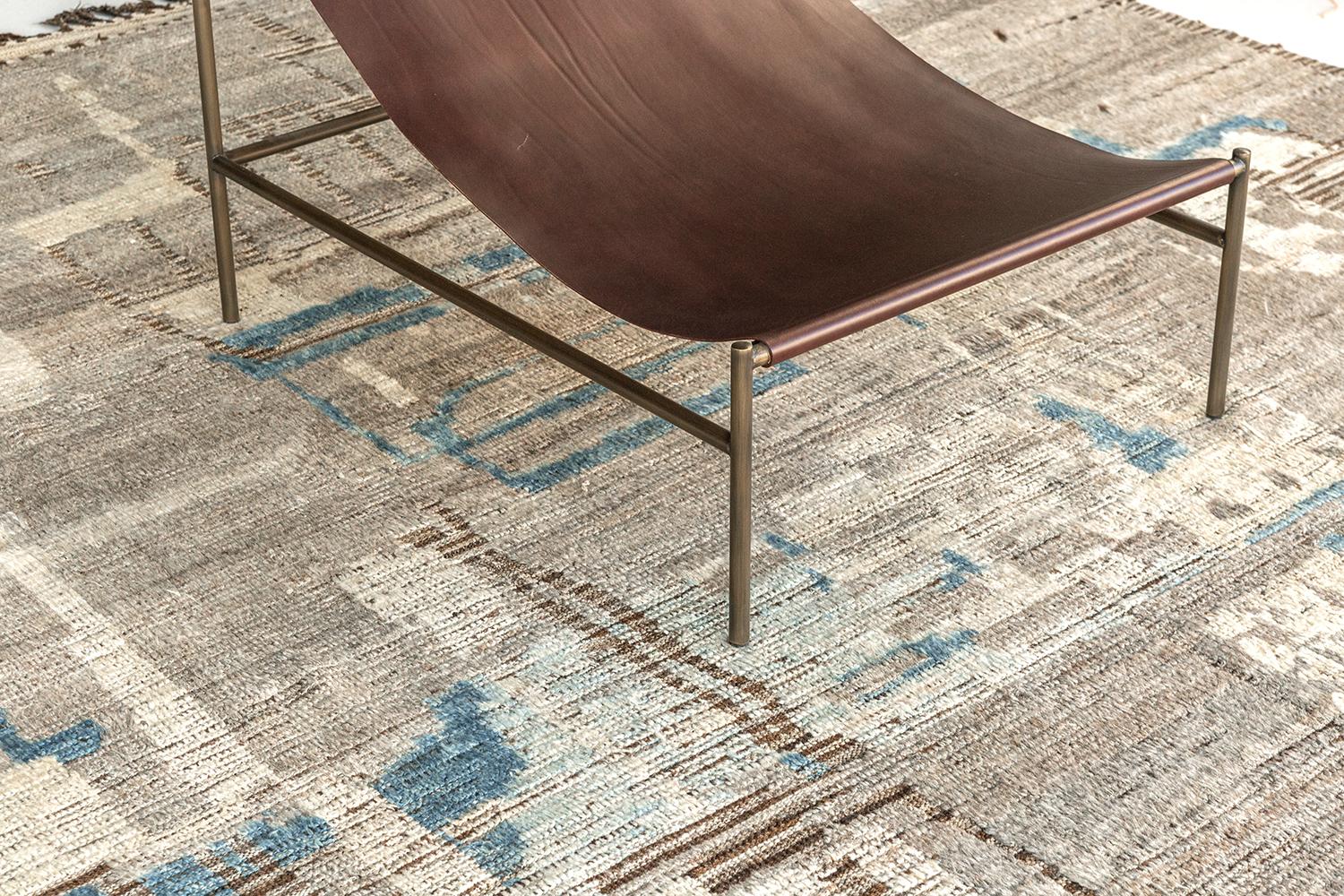 'Meliska' is an exquisitely textured rug with irregular motifs inspired from the Atlas Mountains of Morocco. Earthy tones of ivory and chocolate brown and turquoise surrounded by umber brown shag work cohesively to make for a great contemporary