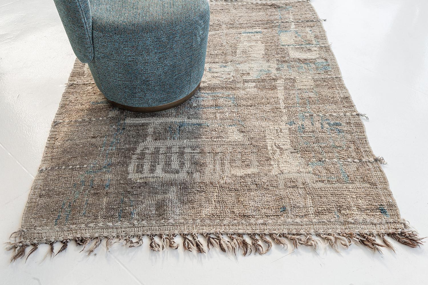 Meliska is a captivating textured rug with irregular motifs inspired by the Atlas Mountains of Morocco. Earthy tones of ivory, blue, and chocolate brown surrounded by umber brown shag work cohesively to make for a great contemporary interpretation
