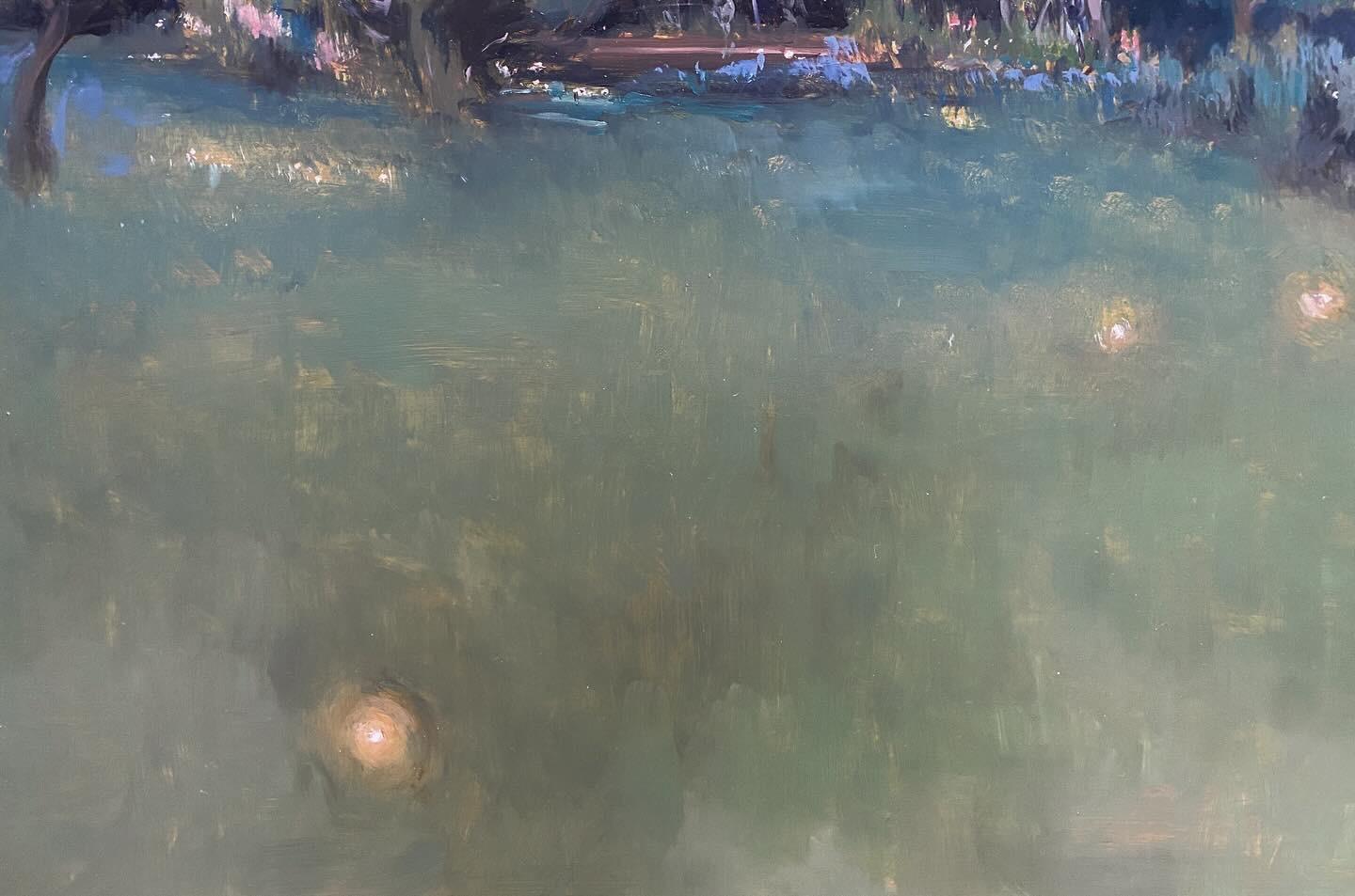 An oil on brass painting of the artist's back yard, at dusk. The distant pale yellow sky above a mountainous horizon is intersected by a tall cypress tree. Dark green hues make up the shrubs and vegetation framing the artist's garden. Hints of brass