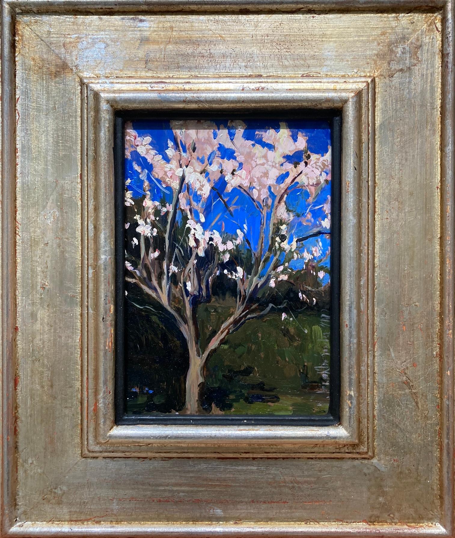 Un dipinto a olio che raffigura un mandorlo su una siepe in ombra. L'albero è leggermente decentrato nella composizione e i suoi rami si protendono verso i bordi della tela su tre lati. I fiori di mandorlo rosa che risplendono alla luce del sole