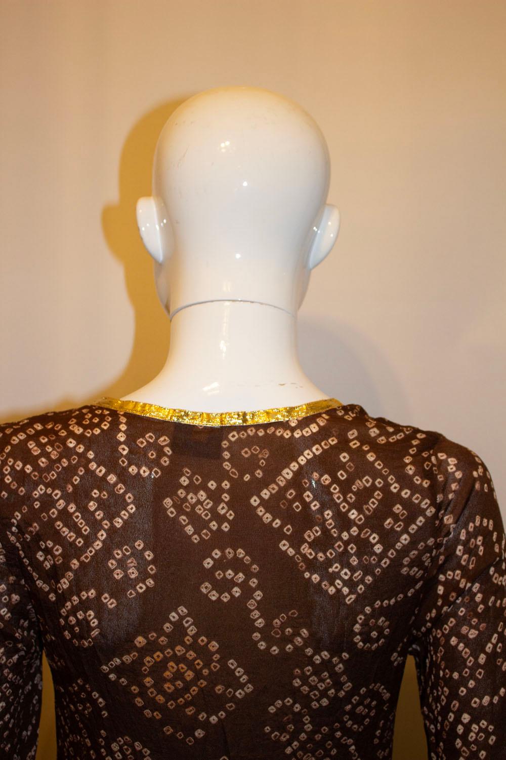  A fun and easy to wear silk tunic top by Melissa Obadash. The top  is in a brown silk with gold detail.  The top is unlined and has a 10'' slit on each side. 
Size M , measurements Bust up to 35'', length 39''