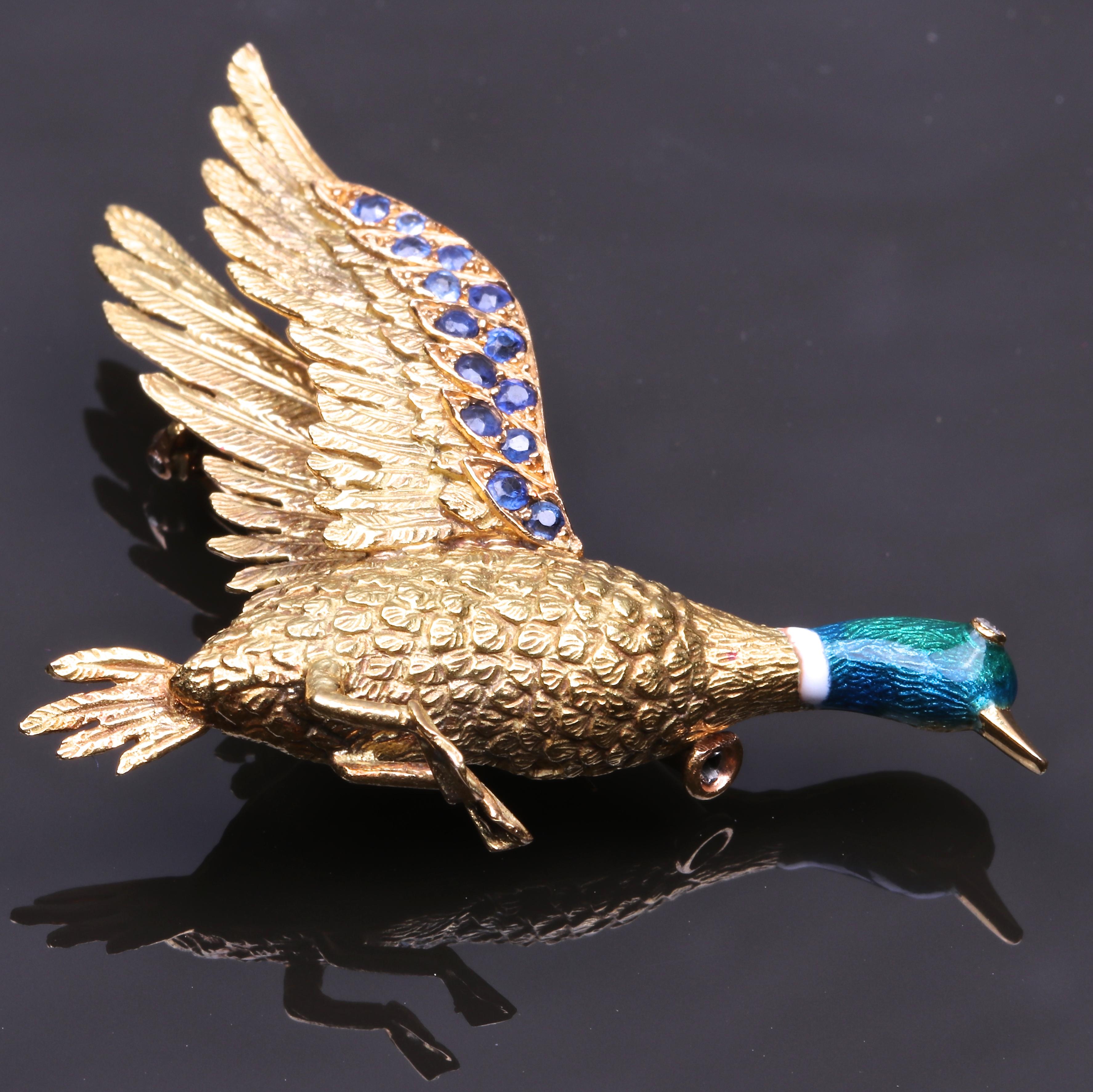 The duck seems to be in full flight while resting on your lapel, a dynamic combination of stillness and movement. This Mellerio brooch features diamonds, sapphires, enamel and is made in 18k gold. There are 14 sapphires weighing approximately 0.45