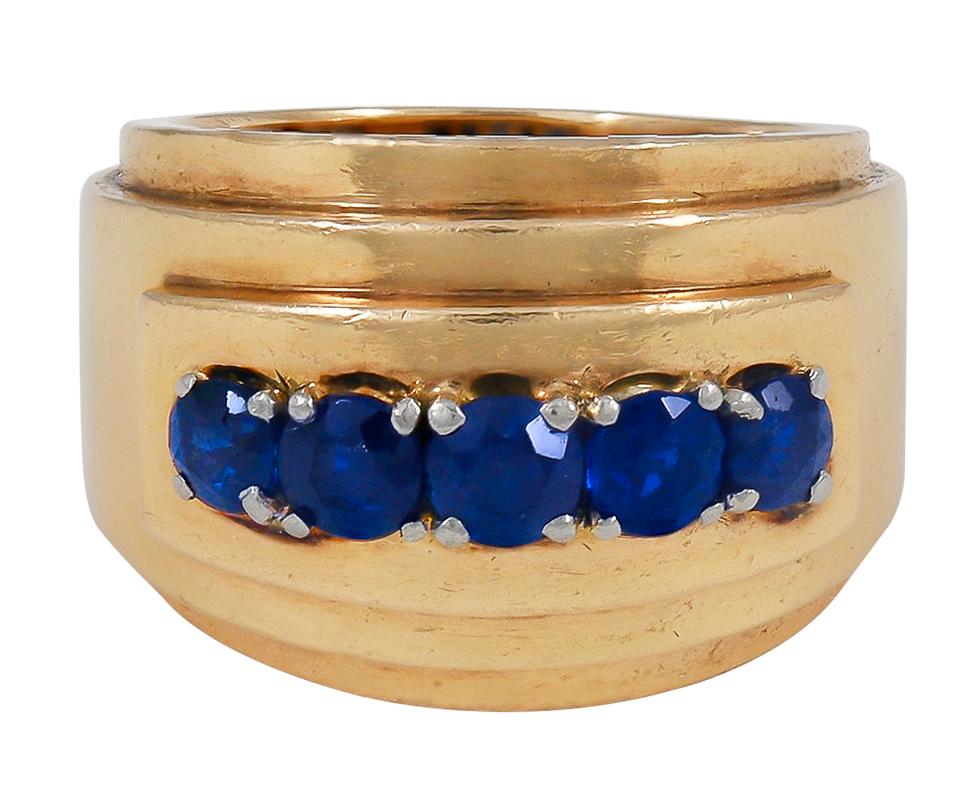 The architectural, wide 18kt yellow gold band decorated across the front with a horizontal row of five circular-cut sapphires in platinum prongs, signed MELLERIO DITS MELLER, numbered G 05 B (partially obscured), French, ca. 1940, measuring 5/8 inch