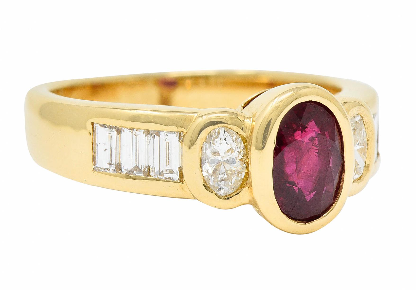 Centering an oval cut ruby weighing approximately 1.10 carats - bright red in color

Bezel set and flanked by two bezel set oval cut diamonds - K/L color

Shoulders are channel set with baguette cut diamonds - G to J color

Total diamond weight is