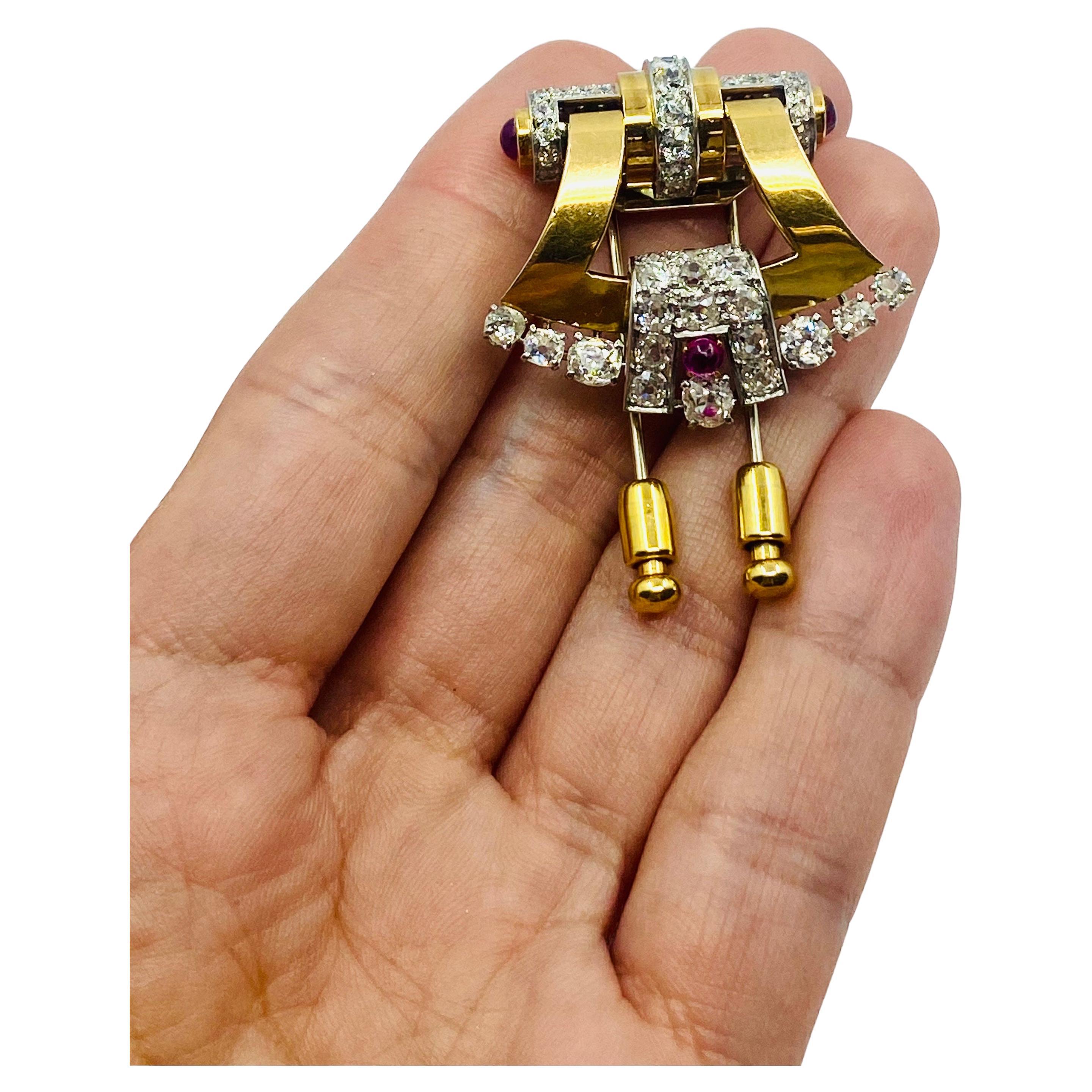 DESIGNER: Mellerio dits Meller
CIRCA: 1950s
MATERIALS: 18K Gold
GEMSTONE:   Round Brilliant Cut Diamonds
GEMSTONE 2:  Ruby
WEIGHT: 21 grams
MEASUREMENTS: 1 1/4” x 1 3/8”
HALLMARKS: Mellerio dits Meller, C2796, French mark

A gorgeous retro brooch by