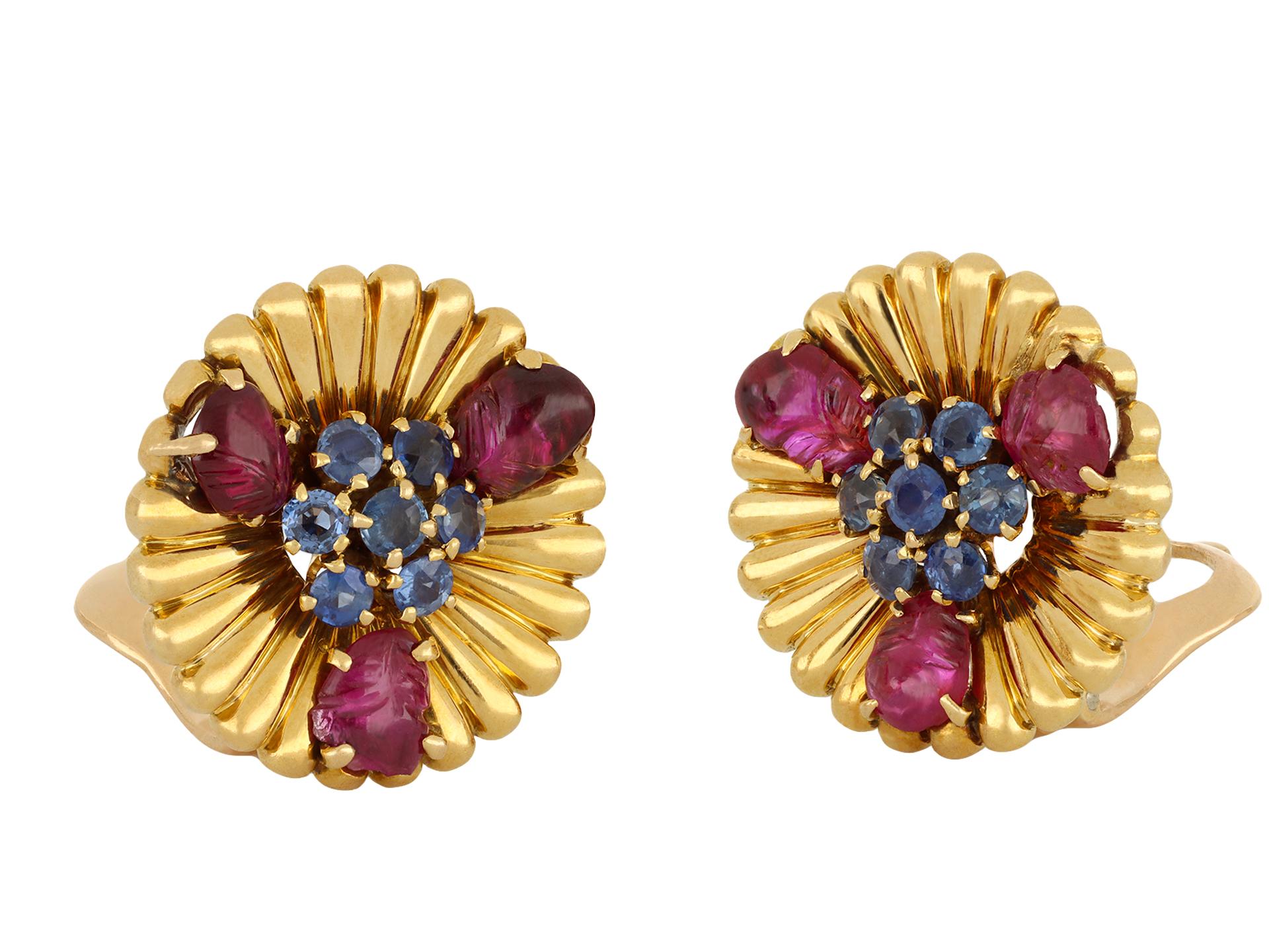 Mellerio sapphire and ruby clip earrings. A matching pair, each set with seven round old cut natural unenhanced sapphires in open and closed back claw settings, fourteen in total, with a combined approximate weight of 1.00 carats, further adorned by