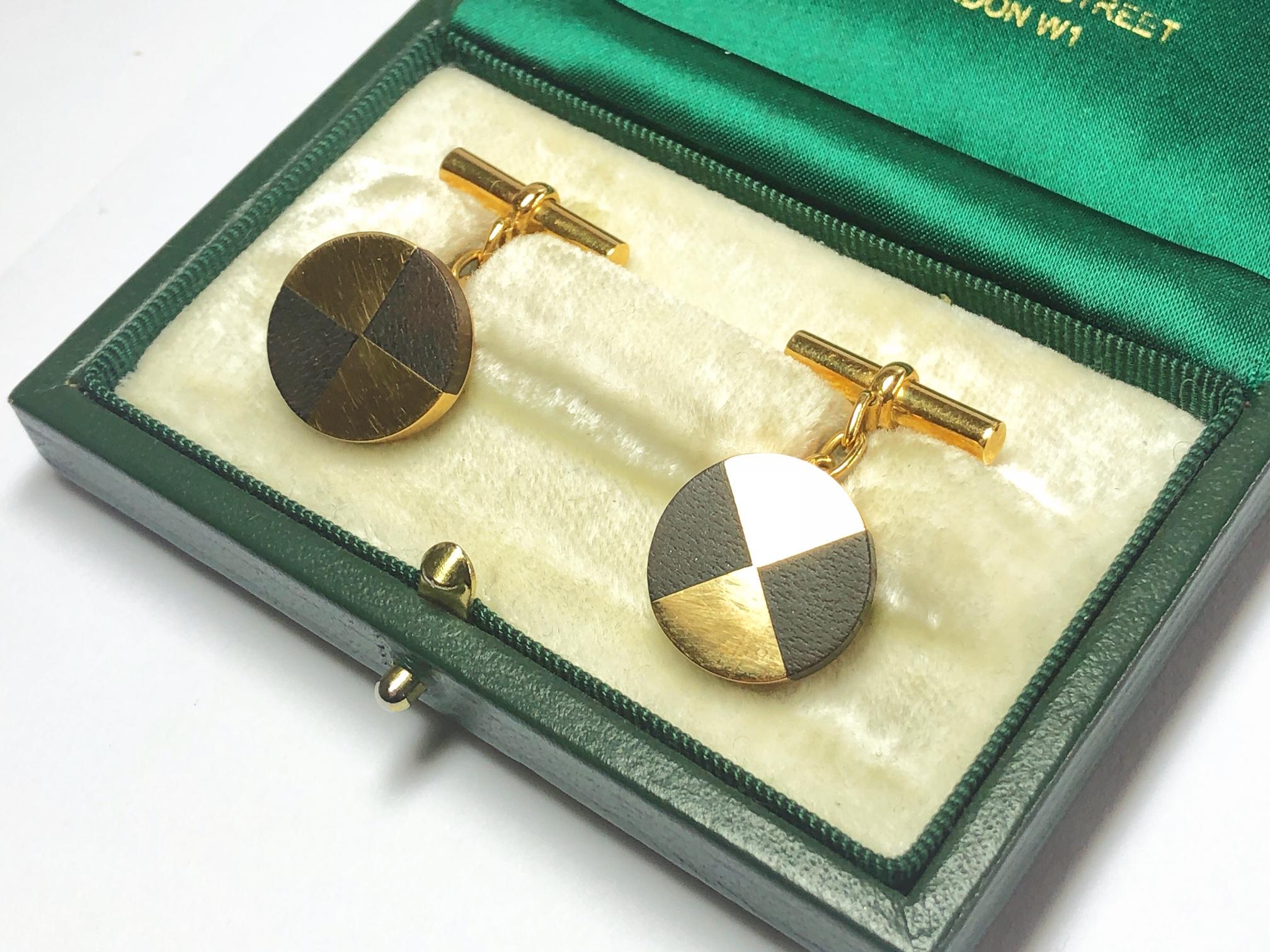 A pair of vintage Mellerio cufflinks, set with two sections of dark wood and two alternate sections of 18ct gold, in circular discs, signed Mellerio, with chain link connections and a bar on the other end, with French eagle marks for 18ct gold,
