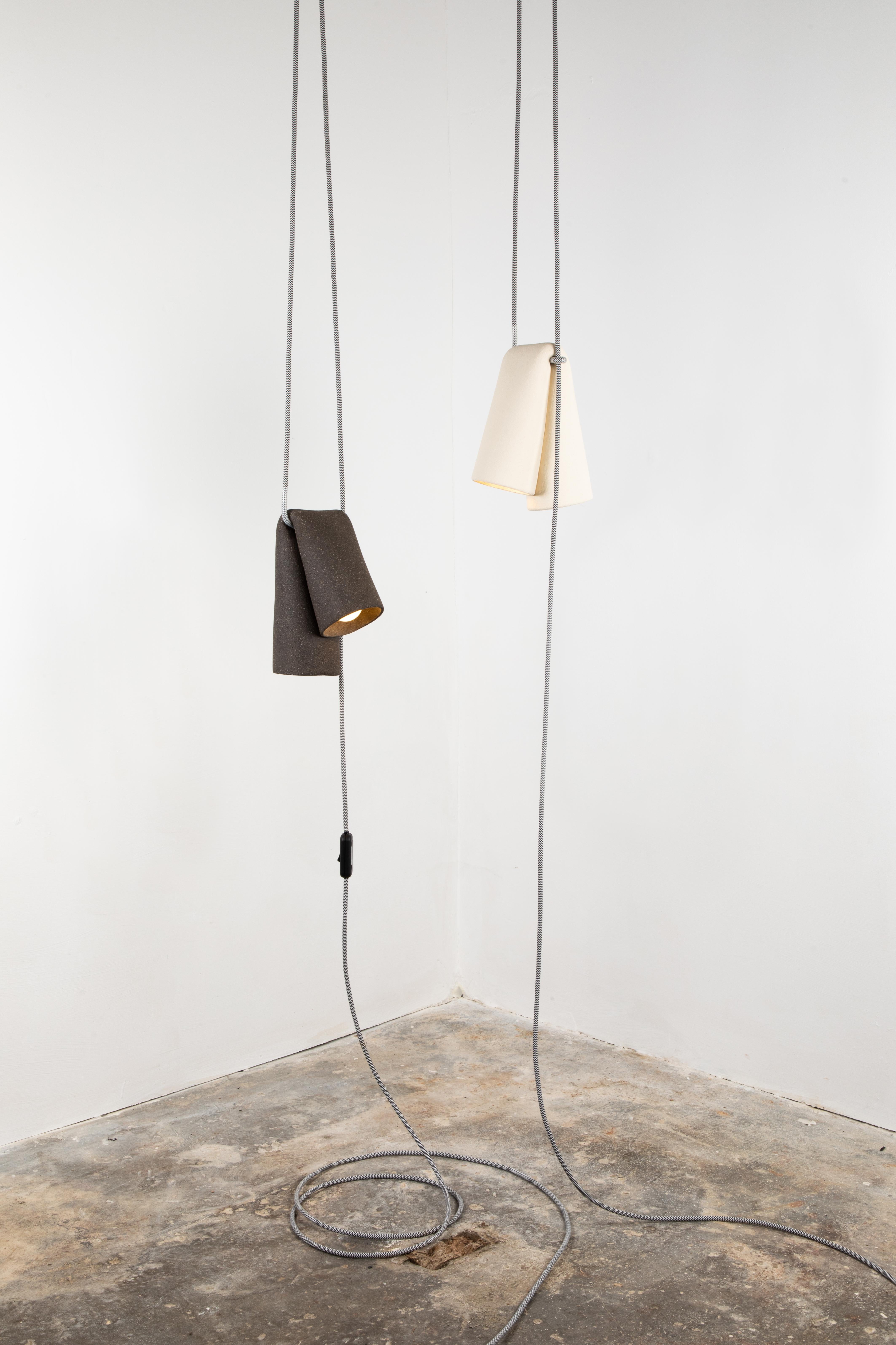 Melo Lamp ist eine skulpturale Keramiklampe, die von der natürlichen Reaktion von rohem Ton auf die Schwerkraft inspiriert ist. Das MATERIAL wird gebogen, gezogen und gedehnt, um diese Formen und die Fließfähigkeit des Tons in einer steinähnlichen