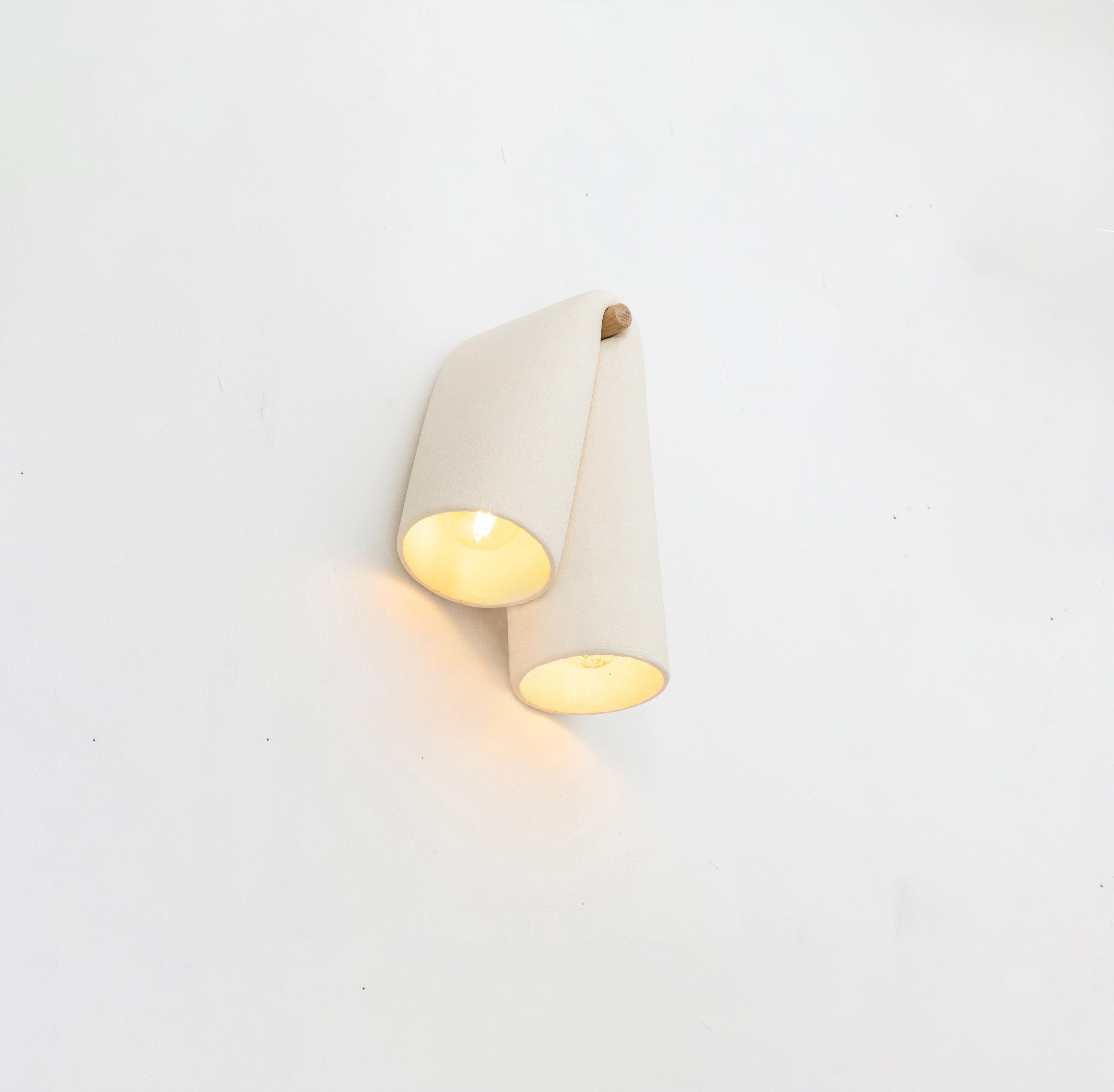 Melo Sconce ist eine skulpturale Keramiklampe, inspiriert von der natürlichen Reaktion von rohem Ton auf die Schwerkraft. Das MATERIAL wird gebogen, gezogen und gedehnt, um diese Formen und die Fließfähigkeit des Tons in einer steinähnlichen Endform