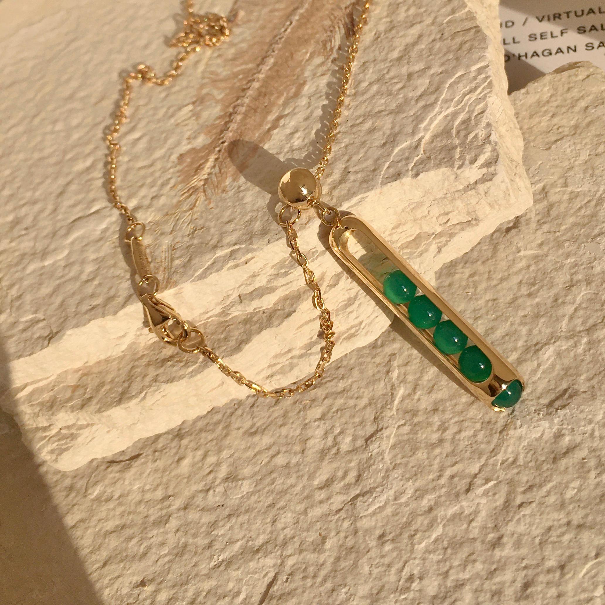 This unique Melody pendant necklace combines perfect hand carved green Chalcedony beads that roll within their 18 karat gold, with 60cm chain. Gold award winning Melody collection is a clever design solution. Each piece incorporates a unique