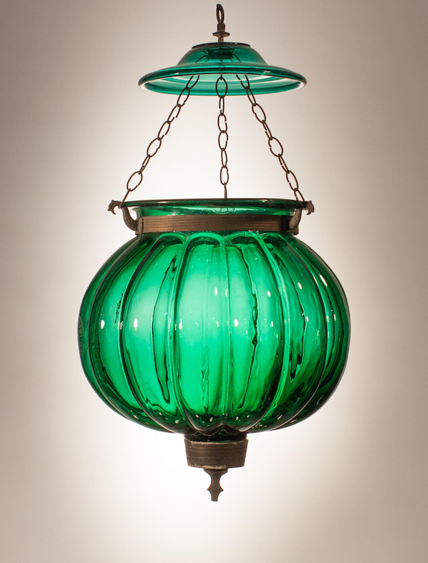 An emerald gem in our bell jar collection, this antique, hand blown glass melon/pumpkin bell jar lantern has brass fittings and a green glass smoke lid. The light will be newly electrified with a three-bulb candelabra cluster and arrives ready to