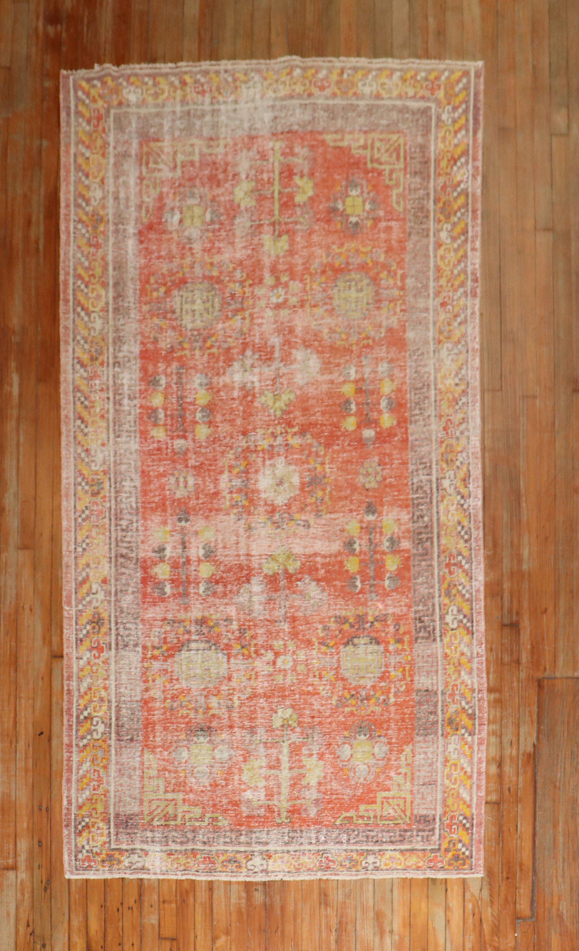 An early 20th-century antique Khotan rug in a predominant red melon color.

Measures: 4'5'' x 8'6''.