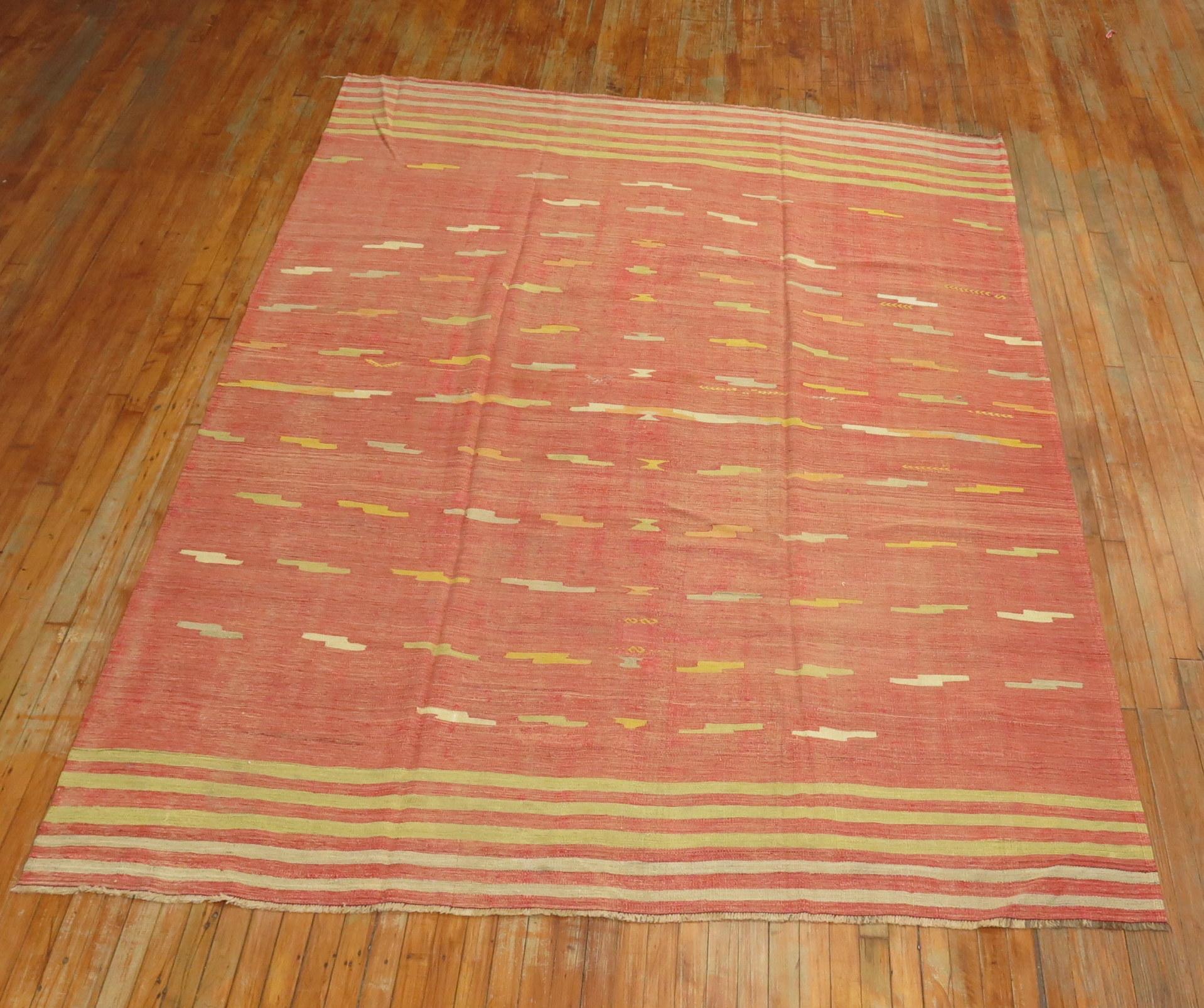 A room size midcentury handwoven predominantly melon red color Turkish flat-weave. The motif on this piece is somewhat unique as it doesn’t really have geometric or floral elements than most kilims have. The weaver was quite creative.
circa 1950.
