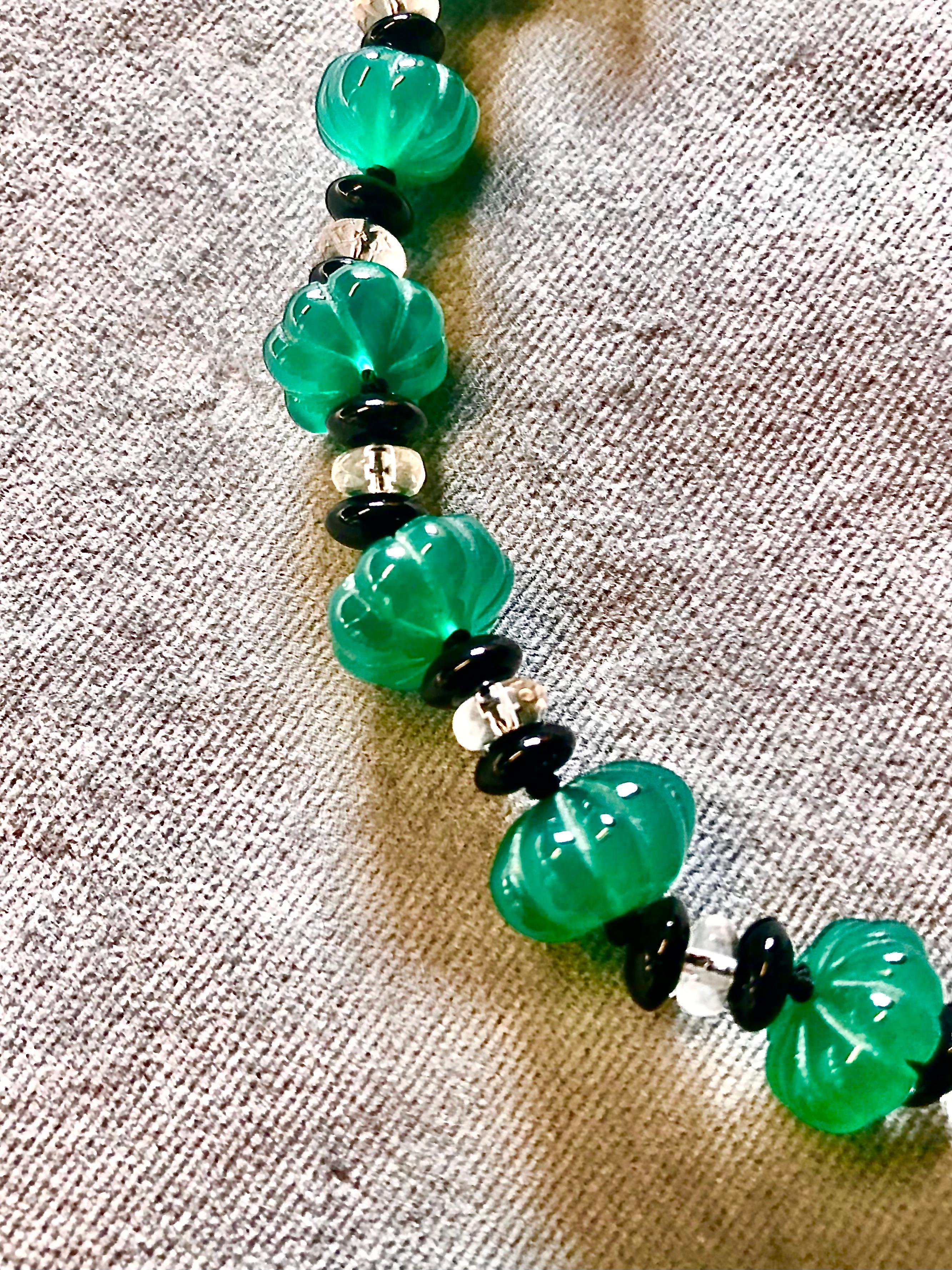 Elegant single strand necklace of translucent green carved melon shaped green onyx rondelles flanked with black onyx rondelles centering on a faceted rock crystal rondelle.

The slightly graduated green onyx melons are the most beautiful glowing