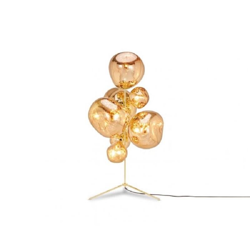An extraordinary floor chandelier, featuring three melt mini shades and four melt shades in a modern gold finish. Emitting an attractive, mildly hallucinogenic light, this floor light creates a mesmerizing melting hot-blown glass effect when on and