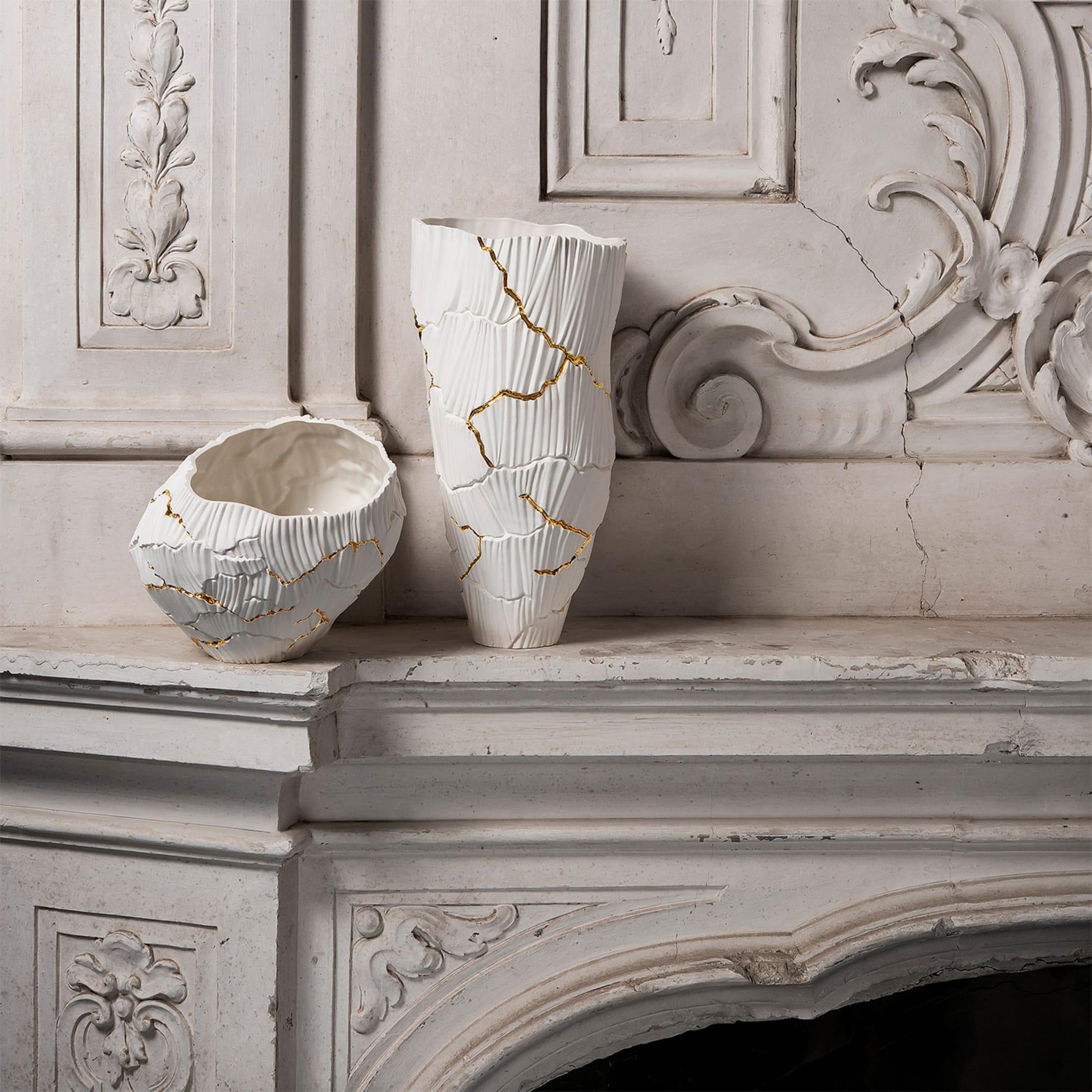 Meltemi is an elegant porcelain vase, part of the Anemos Collection. The soft curves of canals shaped by wind create a unique rhythm on the surface, interrupted by deep cracks, like a dry land that discloses a precious secret. The pure white of