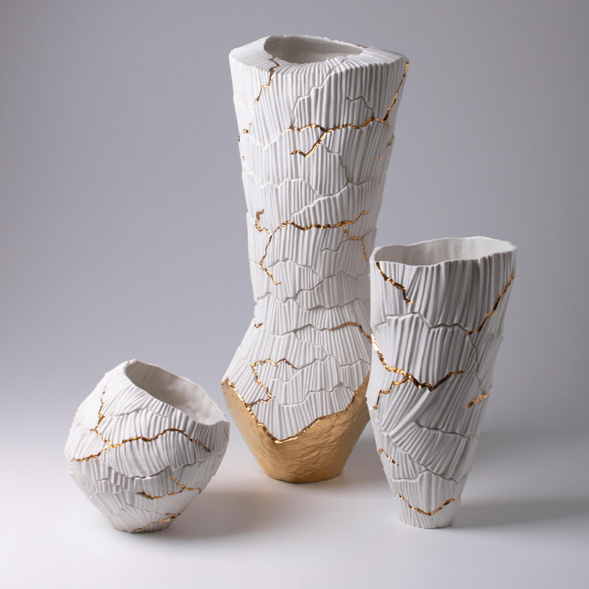 Meltemi ist eine elegante Porzellanvase, die zur Collection'S Anemos gehört. Die sanften Kurven der vom Wind geformten Kanäle schaffen einen einzigartigen Rhythmus auf der Oberfläche, unterbrochen von tiefen Rissen, wie ein trockenes Land, das ein