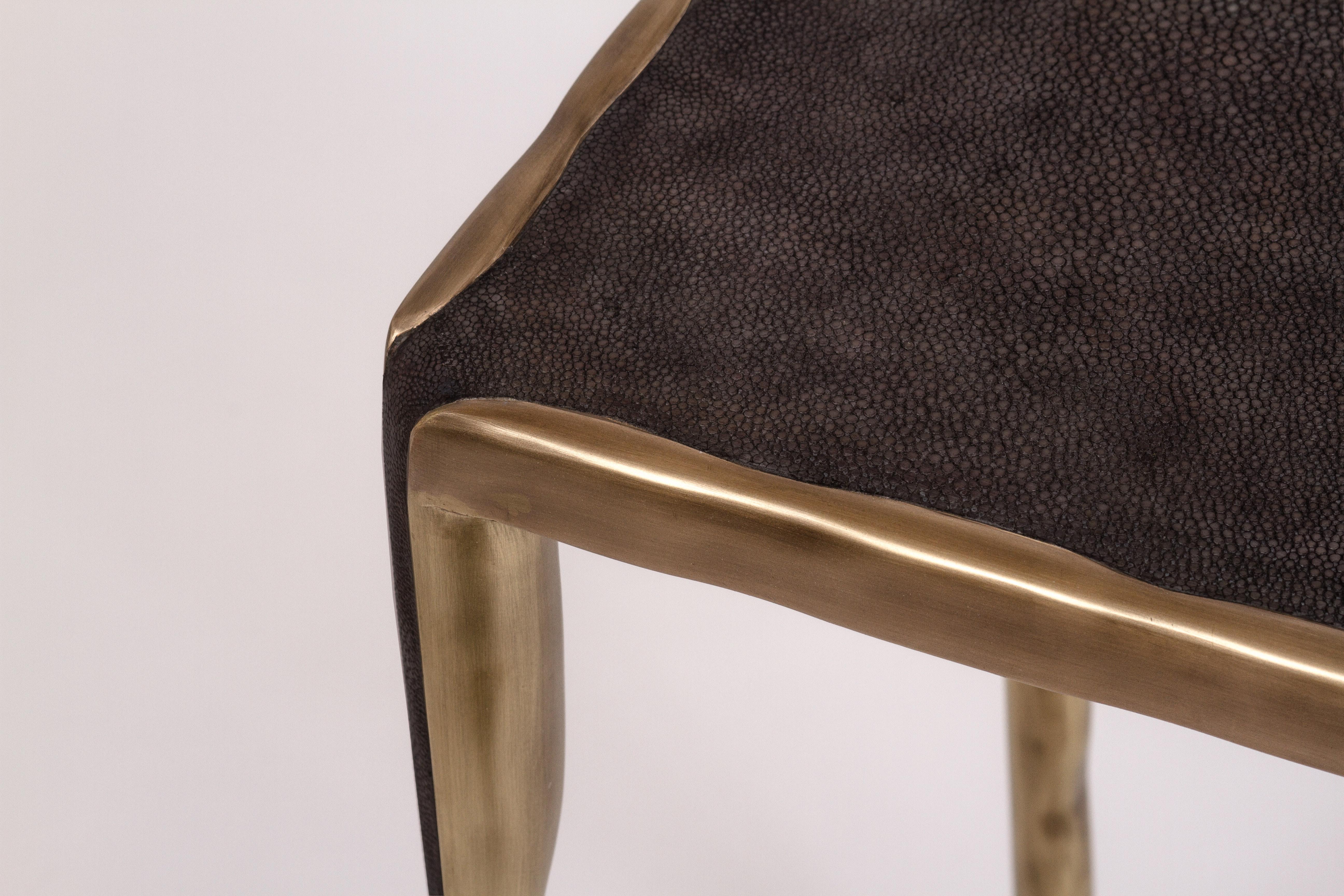 The melting nesting side table in medium is part of a series of nesting side tables (sold separately). One can purchase the tables on their own or buy them as a set to create elegant & geometric shapes. This piece is inlaid in coal black shagreen